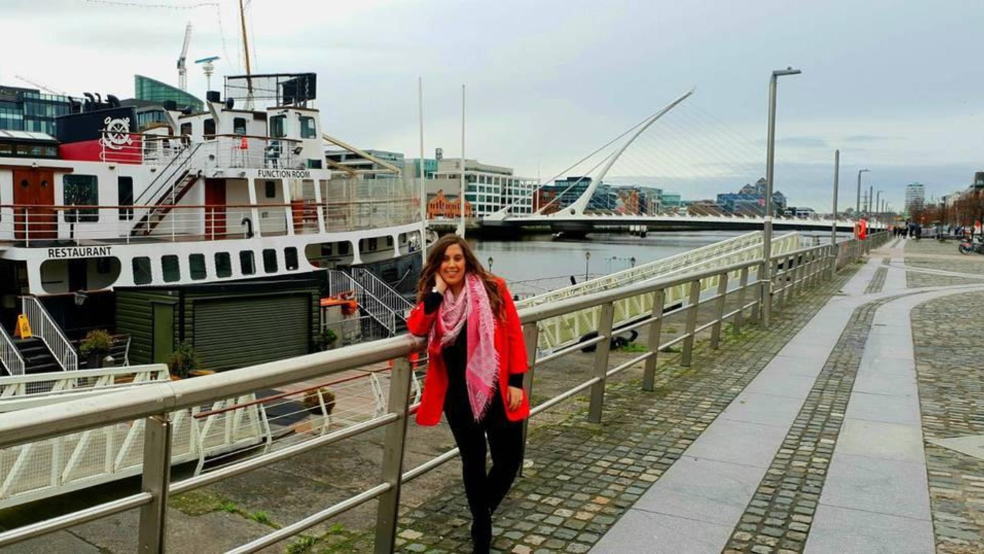 Marta Domínguez, en un embarcadero del río Liffey; al fondo, el puente Samuel Beckett, diseño de Calatrava.