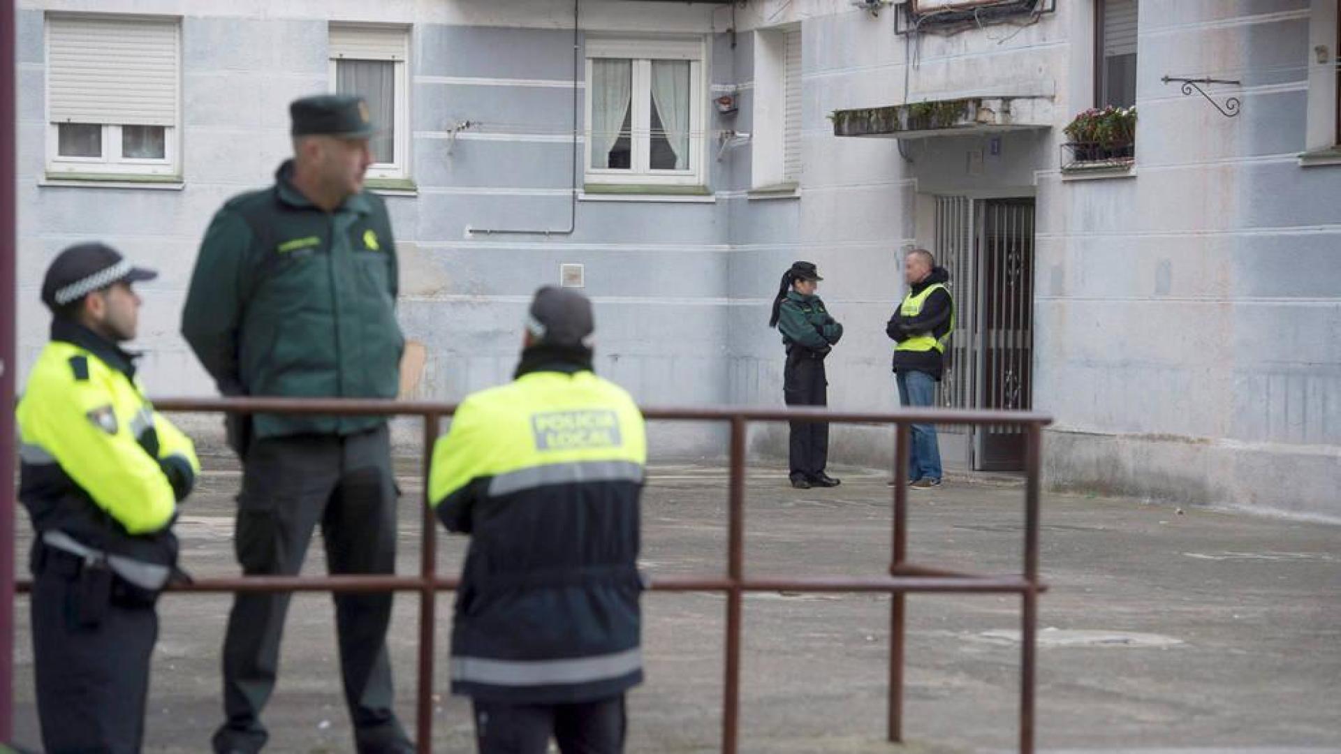 Agentes de la Guardia Civil en el portal del domicilio en el que una mujer de 26 años ha sido asesinada a puñaladas supuestamente por su novio en Laredo.