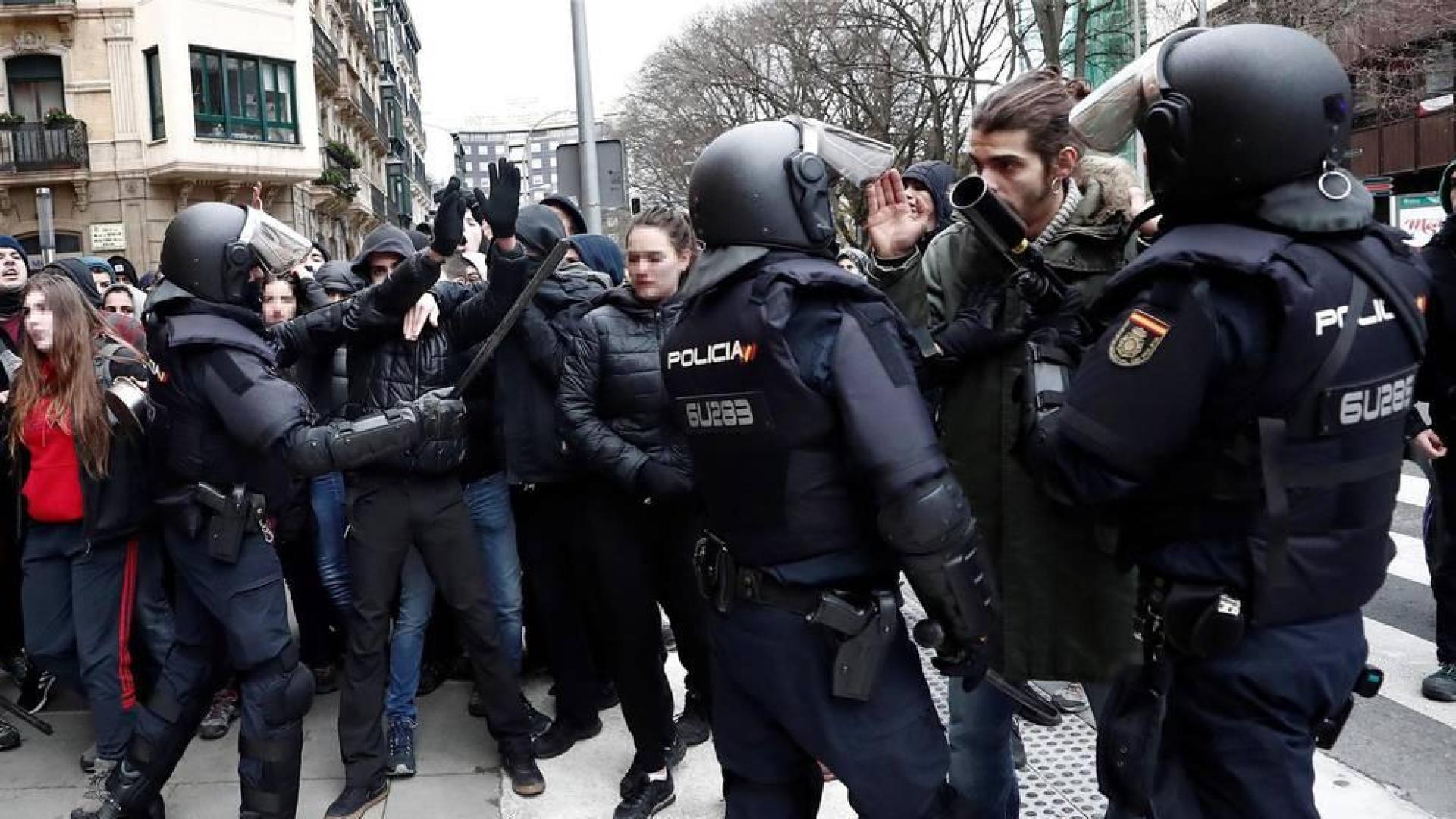 Efectivos de la Policía Nacional disuelven una concentración que han llevado a cabo un centenar de jóvenes junto al Parlamento de Navarra donde han acudido para protestar por la intervención de la Policía Foral esta madrugada en el palacio del Marqués de Rozalejo.