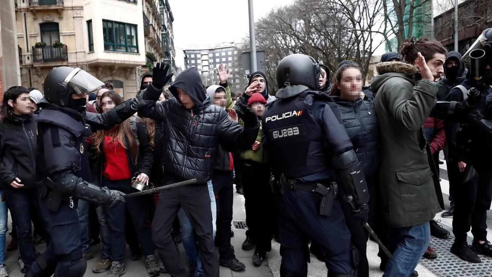 Efectivos de la Policía Nacional disuelven una concentración que han llevado a cabo un centenar de jóvenes junto al Parlamento de Navarra donde han acudido para protestar por la intervención de la Policía Foral esta madrugada en el palacio del Marqués de Rozalejo.
