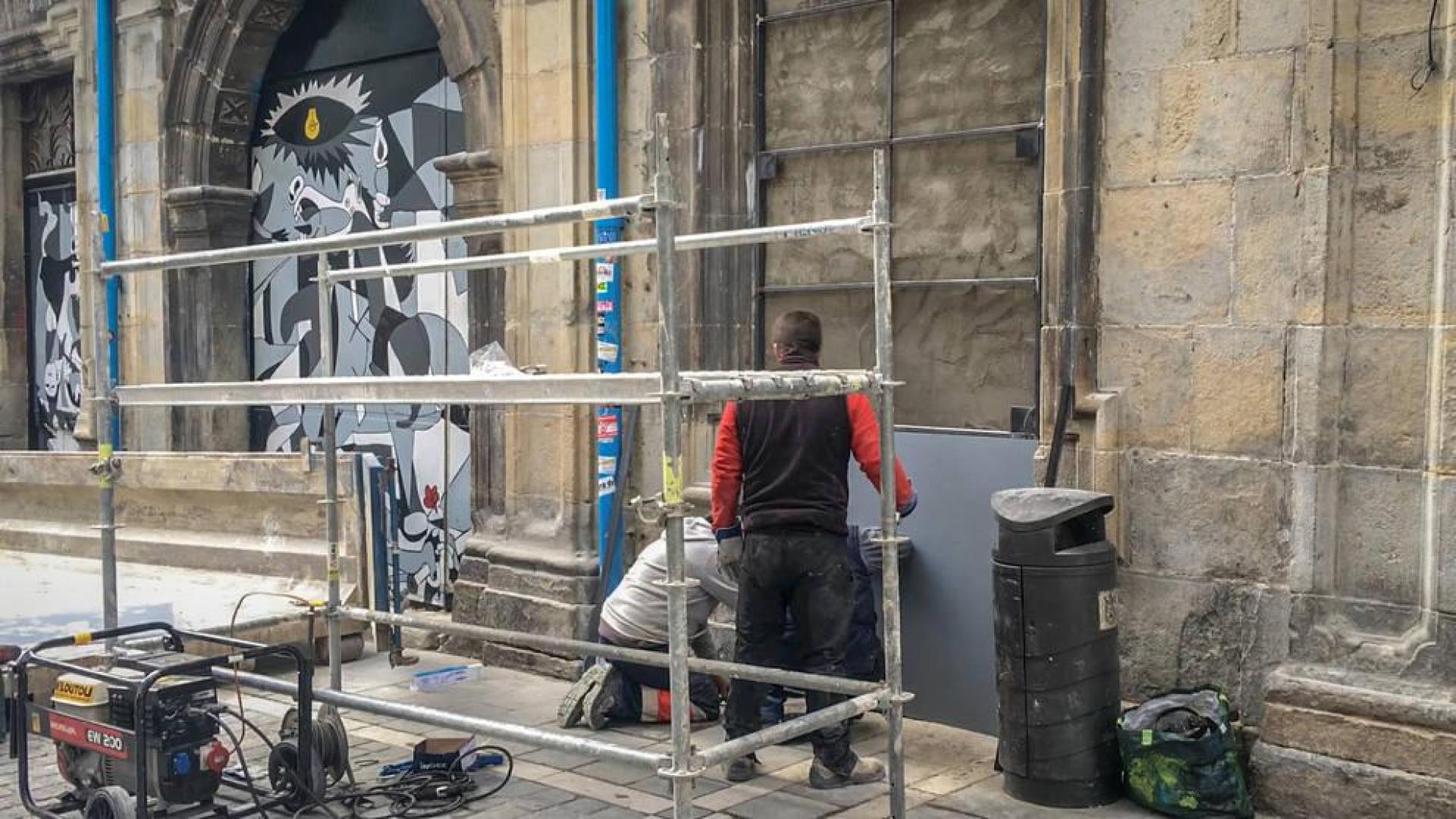 Varios operarios reparan y refuerzan la puerta dañada este jueves en Rozalejo