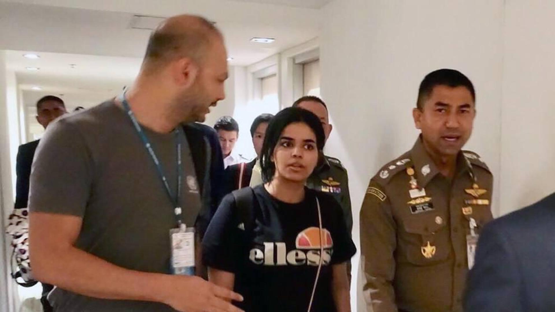 La joven saudí, Rahaf Mohammed Al-Qunun (c), conversa con el jefe de la policía de inmigración de Tailandia, Surachet Hakparn (d), y un trabajador de ACNUR (i) antes de abandonar el aeropuerto Suvarnabhumi en Tailandia.