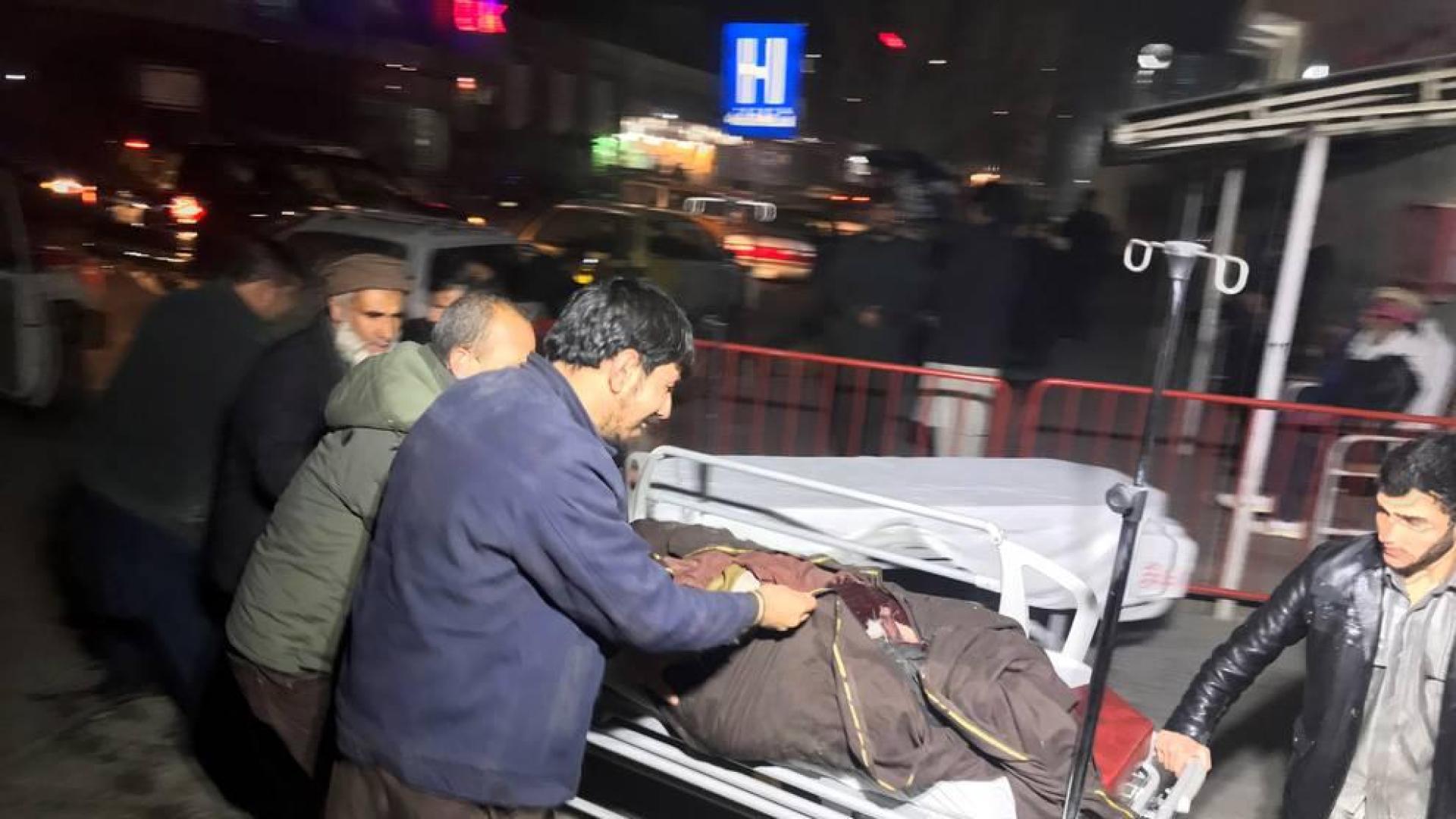Varios hombres trasladan a un herido tras un atentado con coche bomba en Kabul (Afganistán).