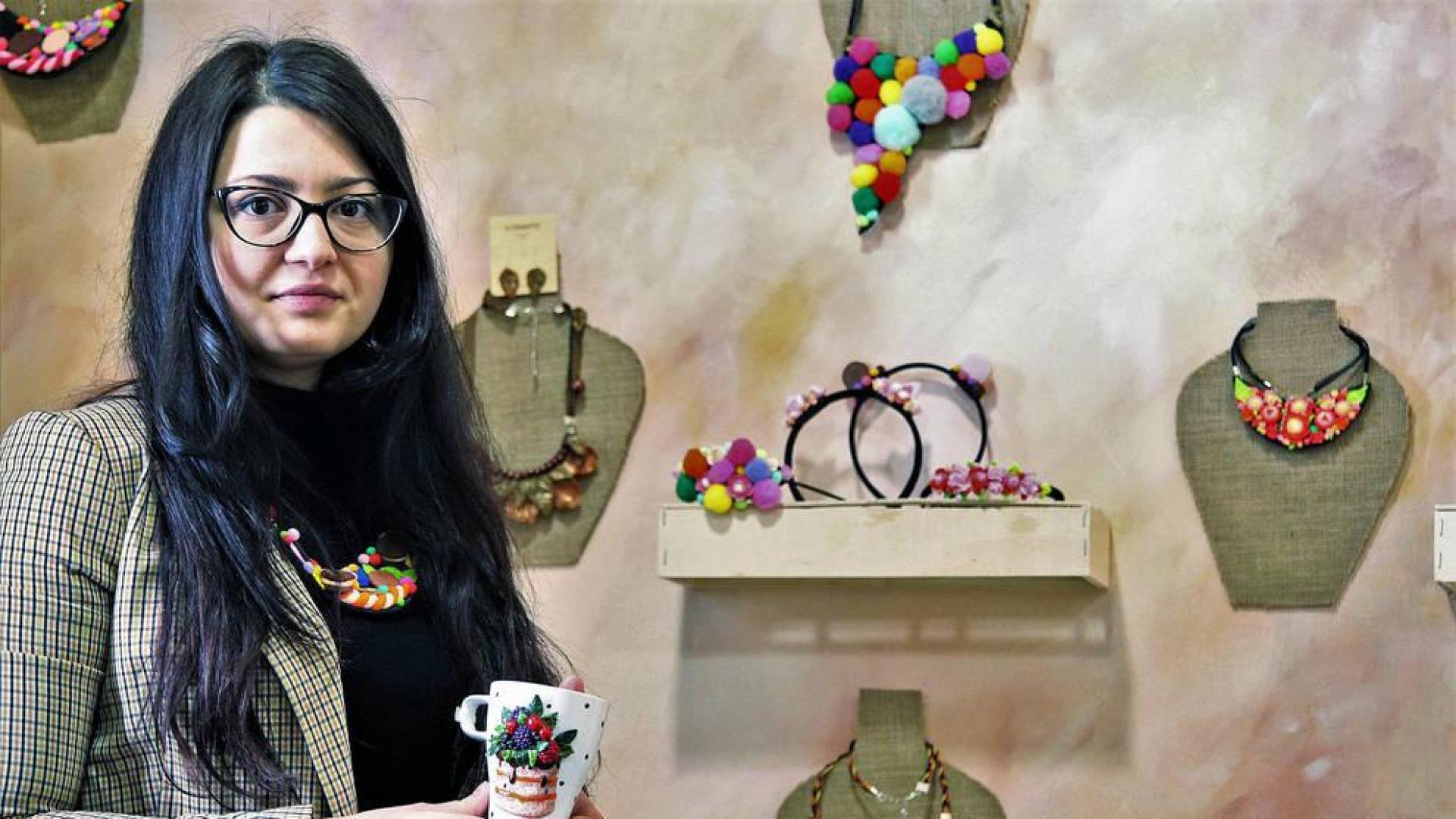 Ilona Chirita sujeta una jarra decorada con pasta polimérica, delante de otras de sus creaciones.