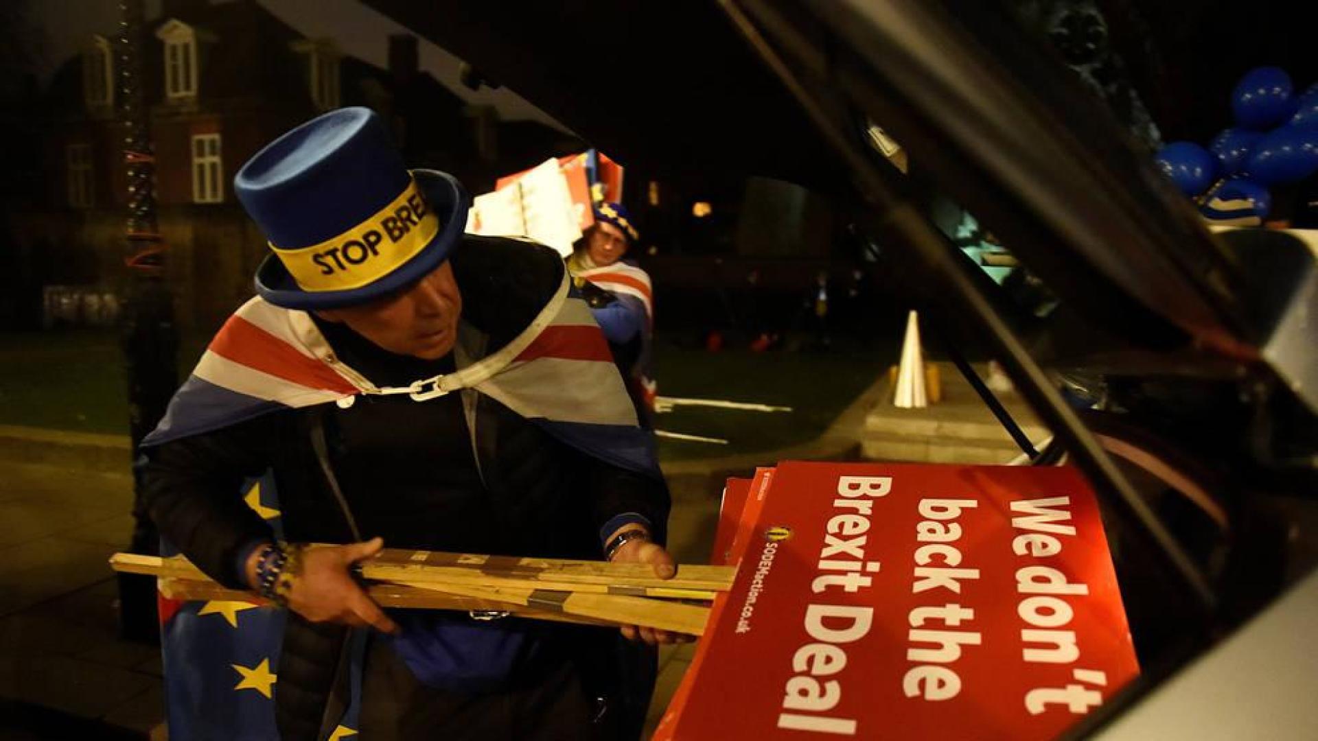 Un manifestante anti Brexit recoge las pancartas tras su protesta.