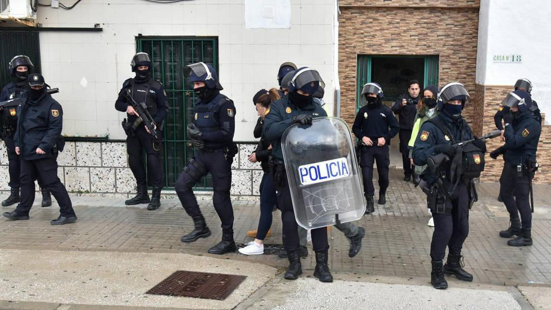 Agentes de la Policía Nacional salen con una detenida en un bloque de la barriada gaditana del Saladillo en Algeciras.