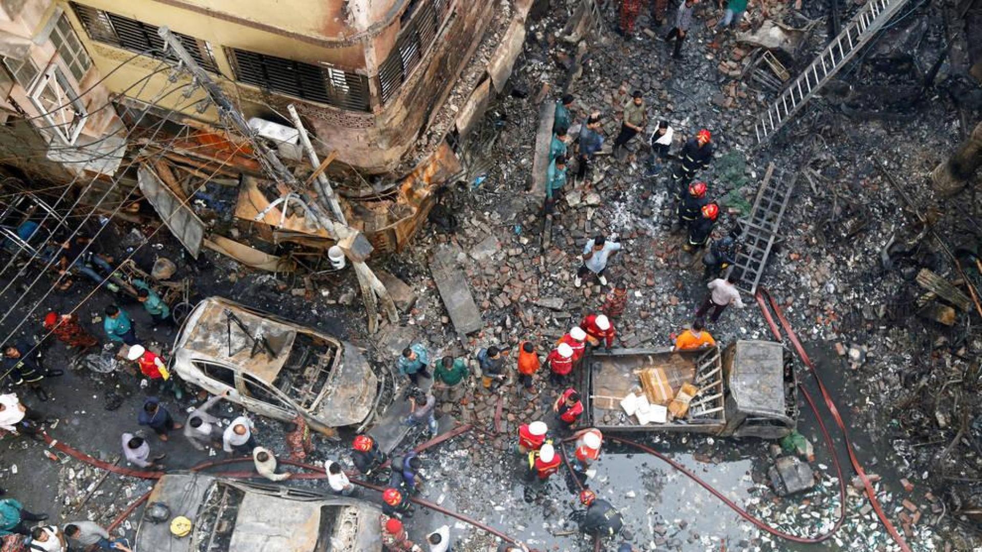 Varios bomberos inspeccionan los escombros tras el incendio declarado en la madrugada de este jueves en el barrio Chawkbazar del casco viejo de Dacca (Bangladesh).