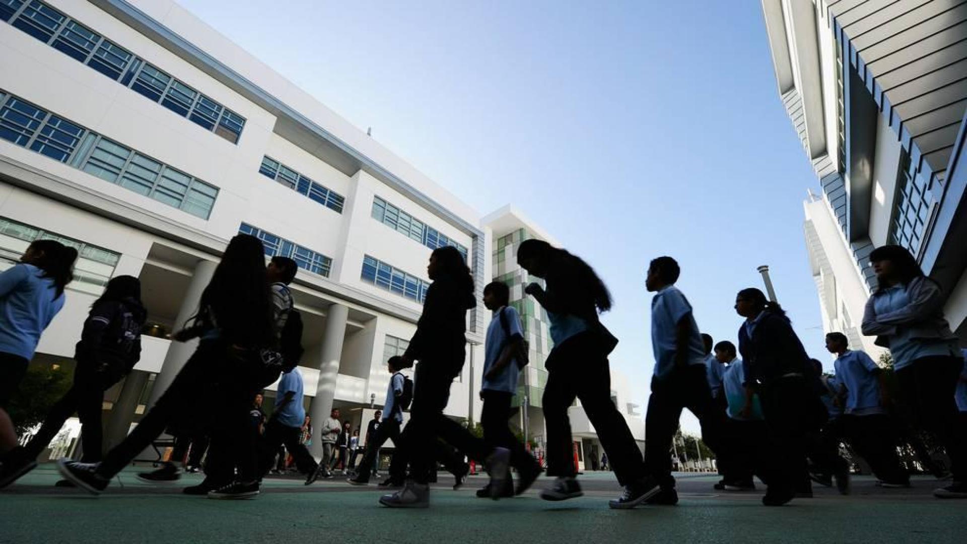 Estudiantes a la entrada de un colegio.
