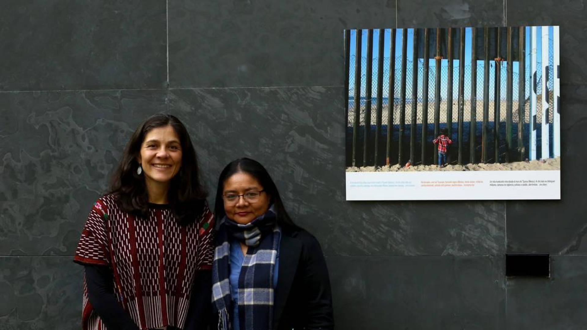 Andrea Villaseñor y Karla Rivas, con una fotografía del periodista Iván Benítez tomada en la valla de Tijuana y que se expone en el Parlamento de Navarra como parte de la muestra 'Stand by: más allá de las fronteras'.