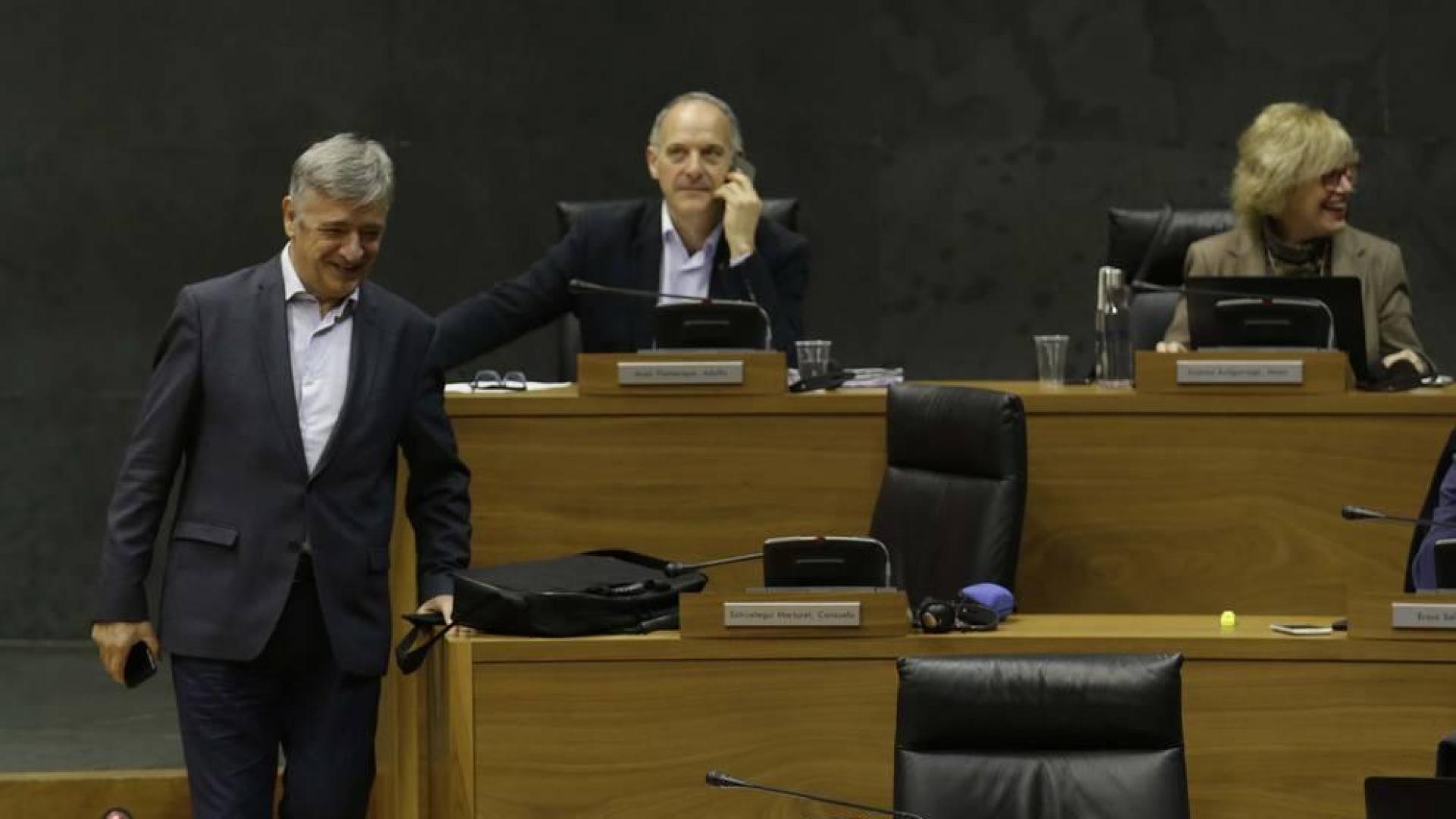 Martínez (Geroa Bai) baja las escaleras del hemiciclo entre Araiz (Bildu) y la presidenta Barkos.