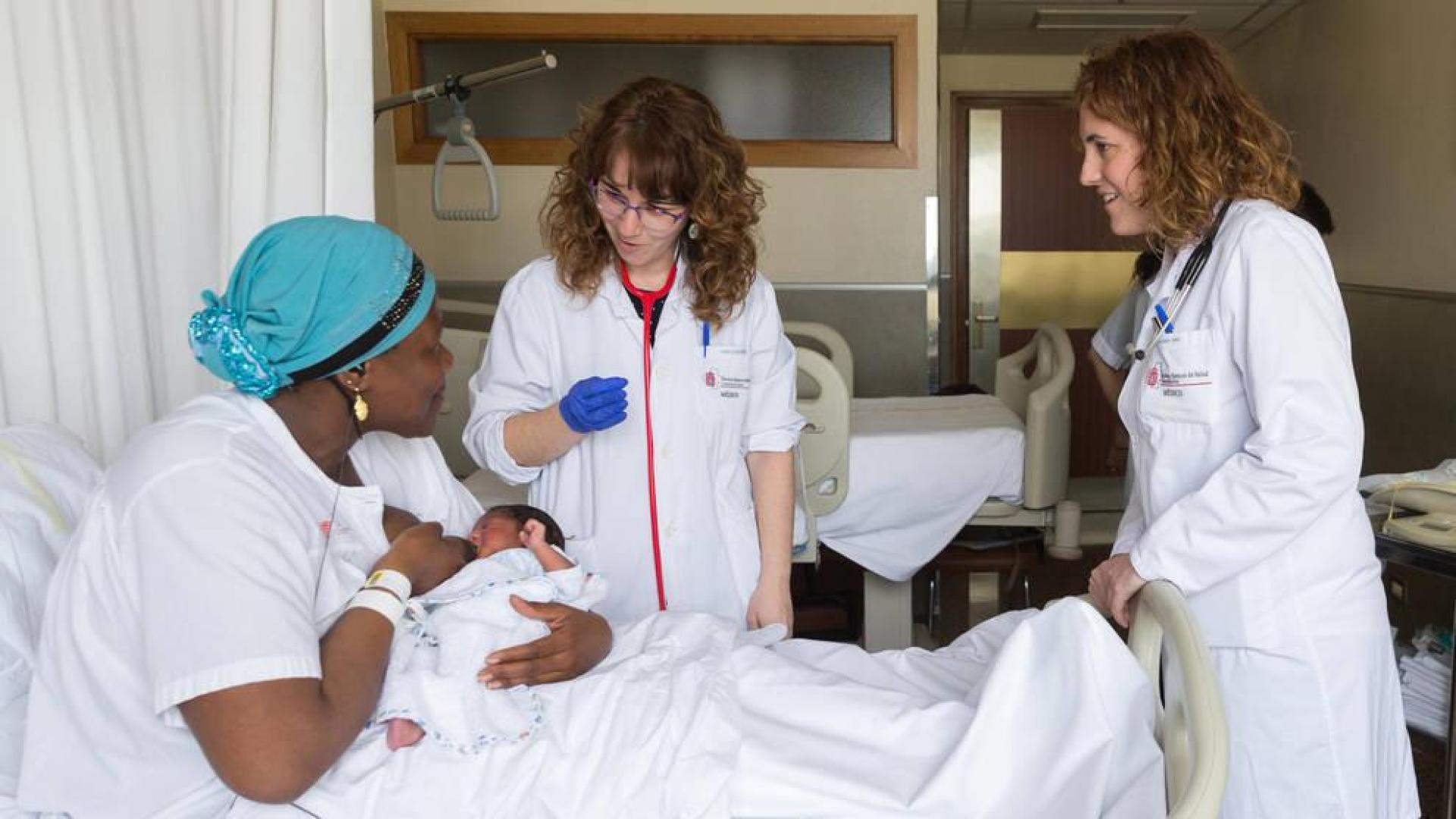 Fily Traore y su hija Niagale Fofana, atendidas por dos profesionales en su habitación del hospital.