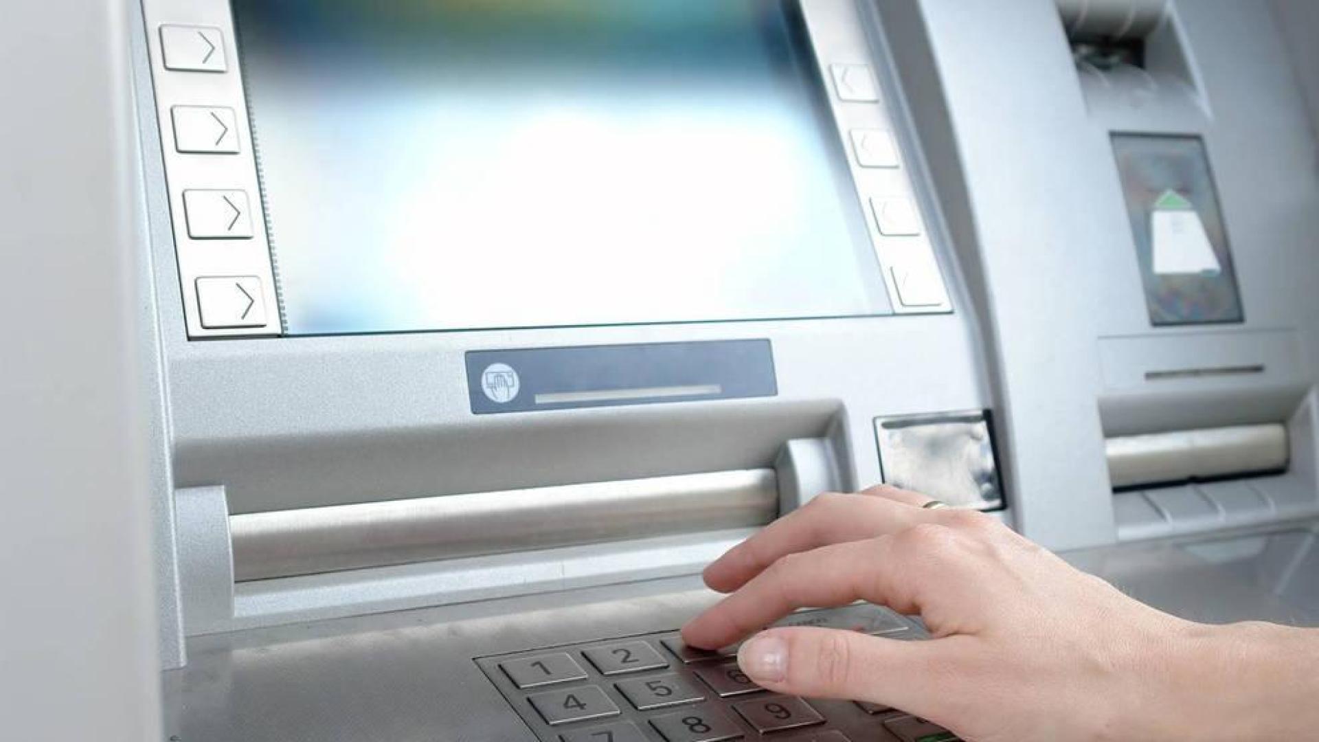 Una persona retira dinero de un cajero automático.