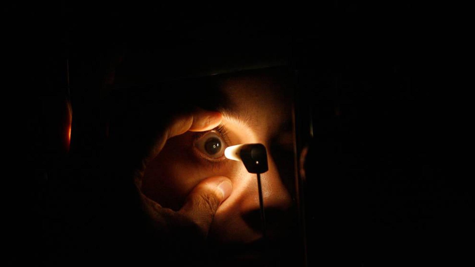 Un oculista examina el ojo de un paciente.