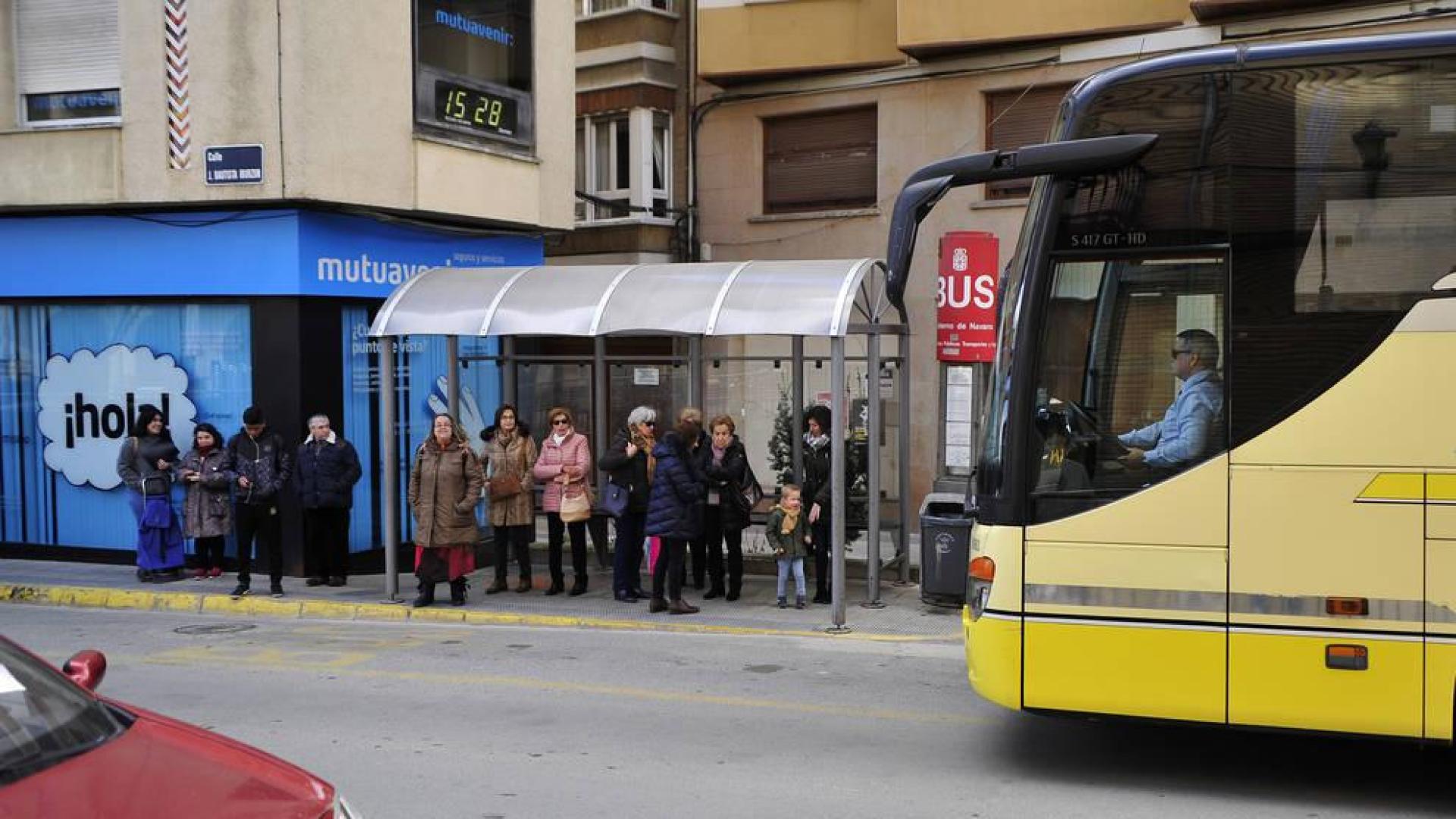 Vecinos esperan en una parada de autobús en Peralta