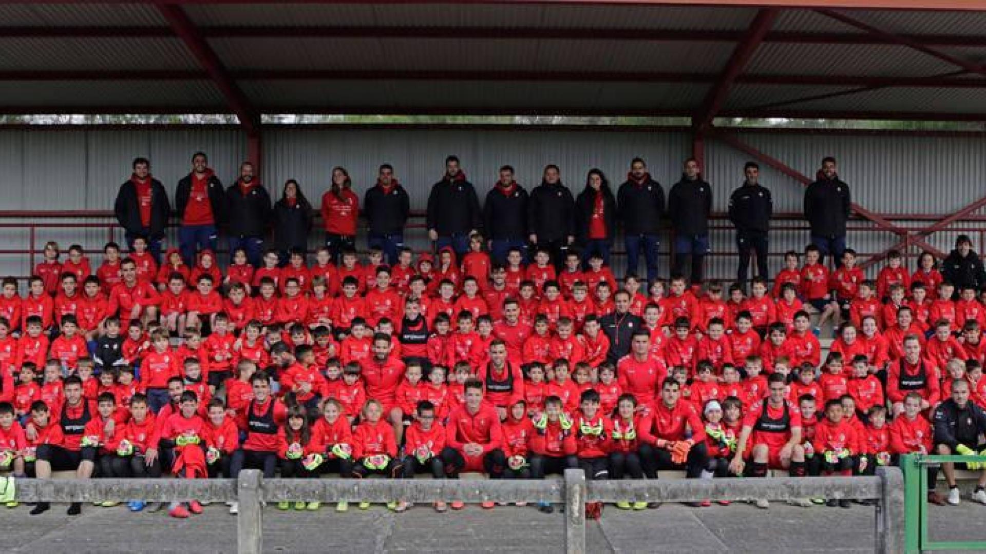 156 alumnos participan en el Campus de Semana Santa que organiza la Fundación Osasuna. Sentados en la grada animaron a los jugadores rojillos mientras realizaban diferentes ejercicios de finalizaciones a portería. Una vez acabada la jornada de trabajo, los futbolistas se acercaron para hacerse una foto.