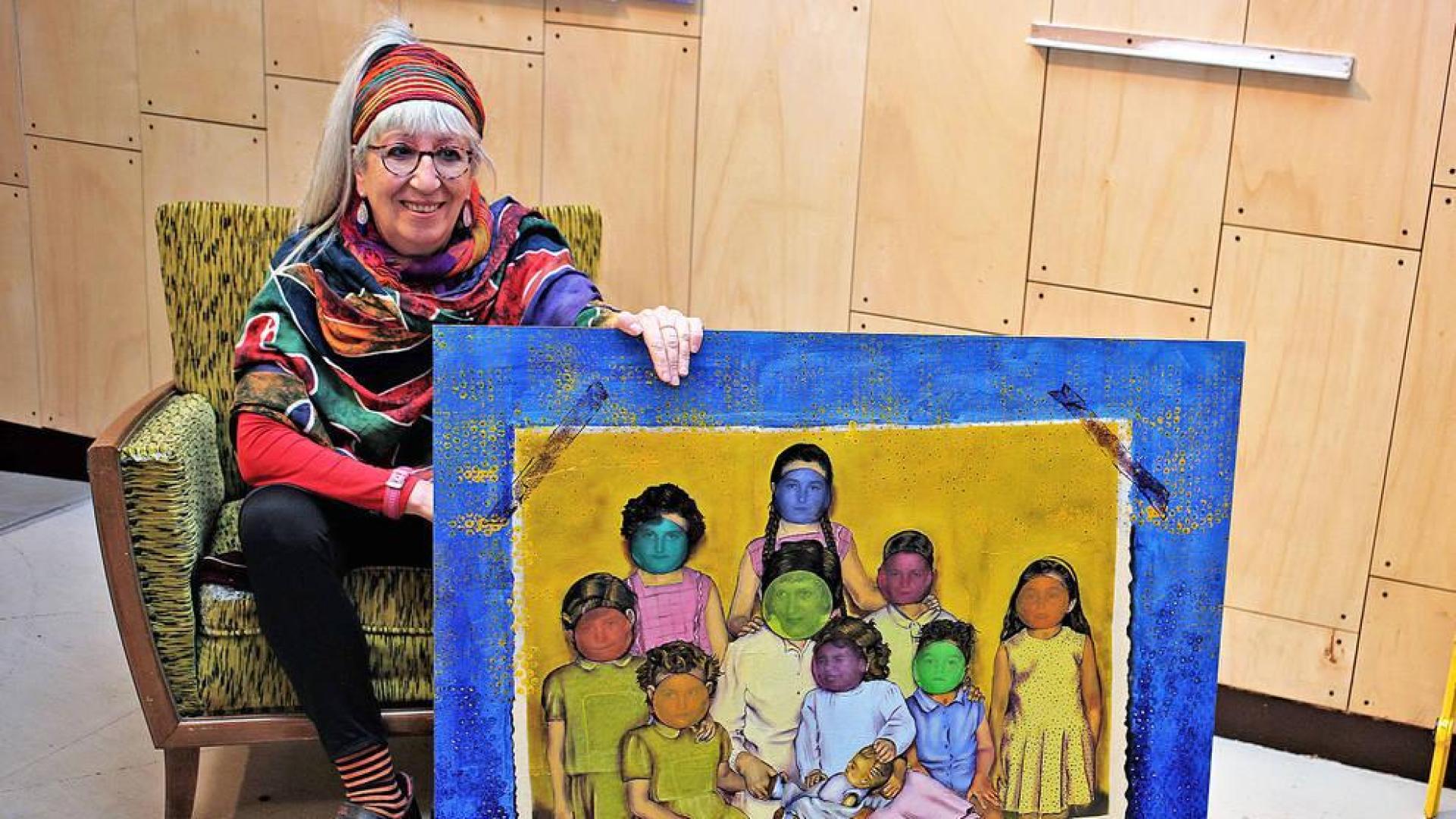 Miren Atxaga, mostrando una de las coloristas obras de su exposición.