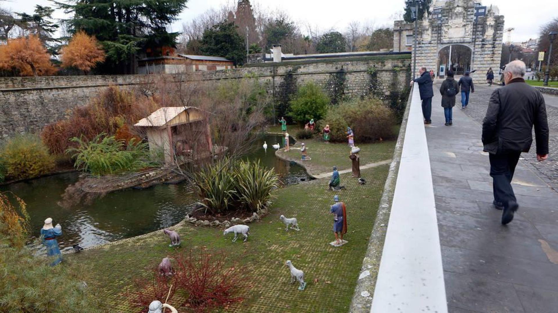 Un hombre camina junto a los fosos de la Taconera, en el estanque de 'los patos' donde está instalado el belén.