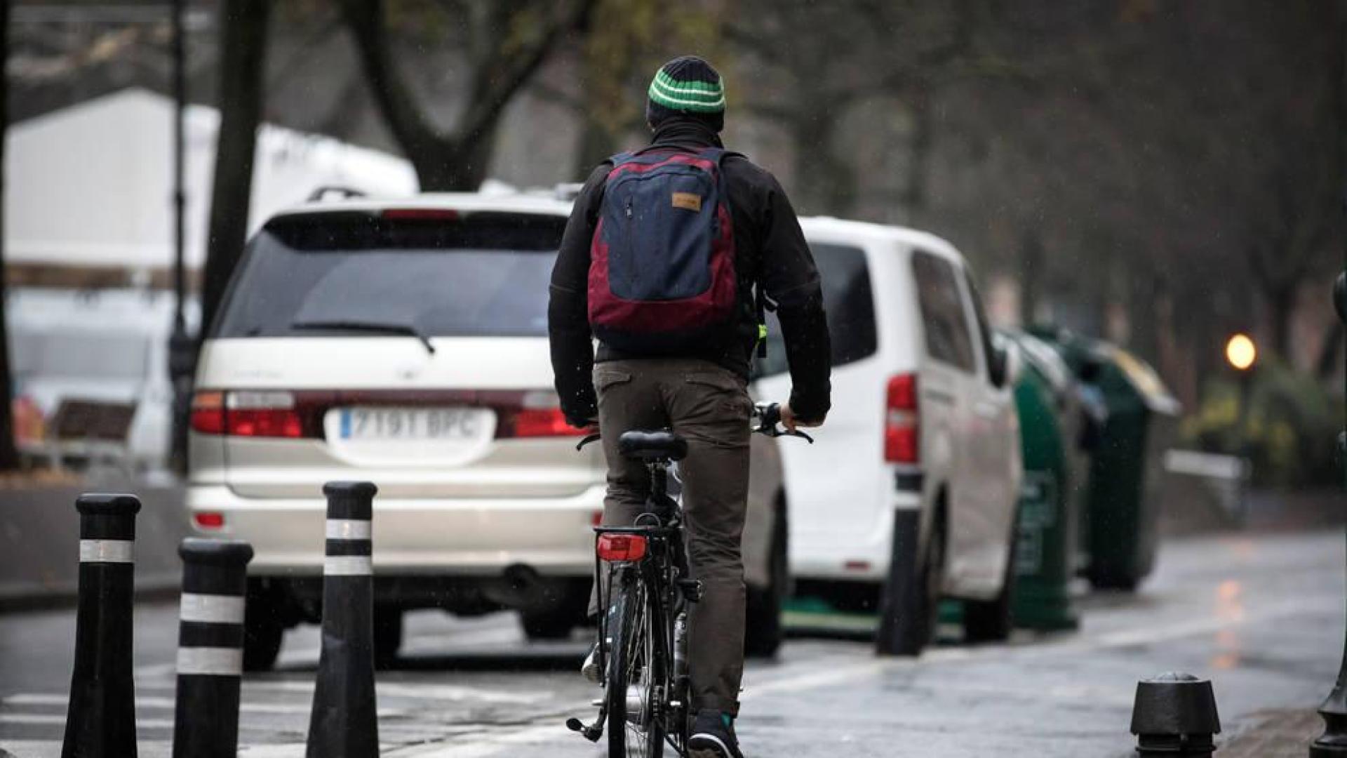 Un hombre en bicicleta, durante una jornada lluviosa en el Paseo Sarasate de Pamplona.