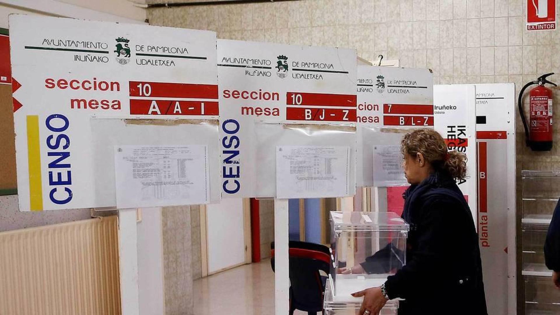 Trabajadores del Ayuntamiento de Pamplona durante la colocación de los paneles, urnas y papeletas en un colegio electoral de la capital navarra.