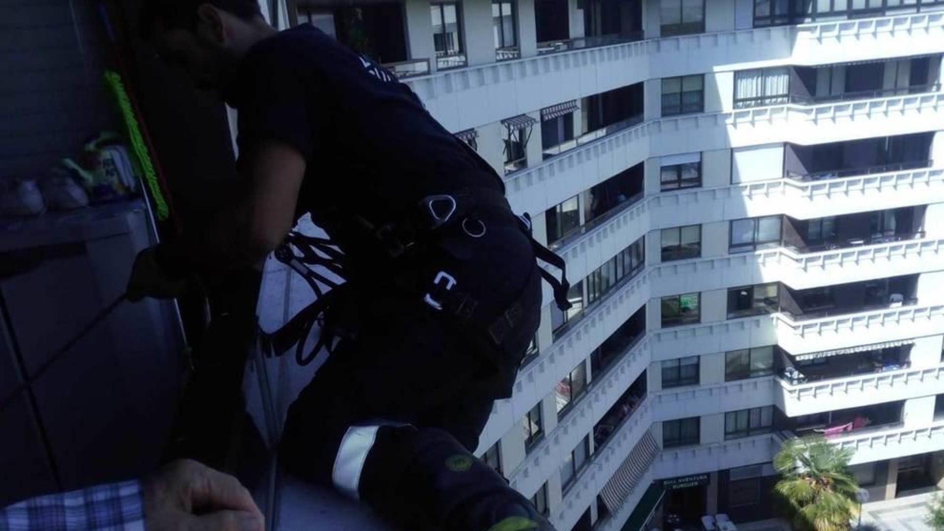 Un bombero, en la ventana de la mujer en la calle Abejeras.