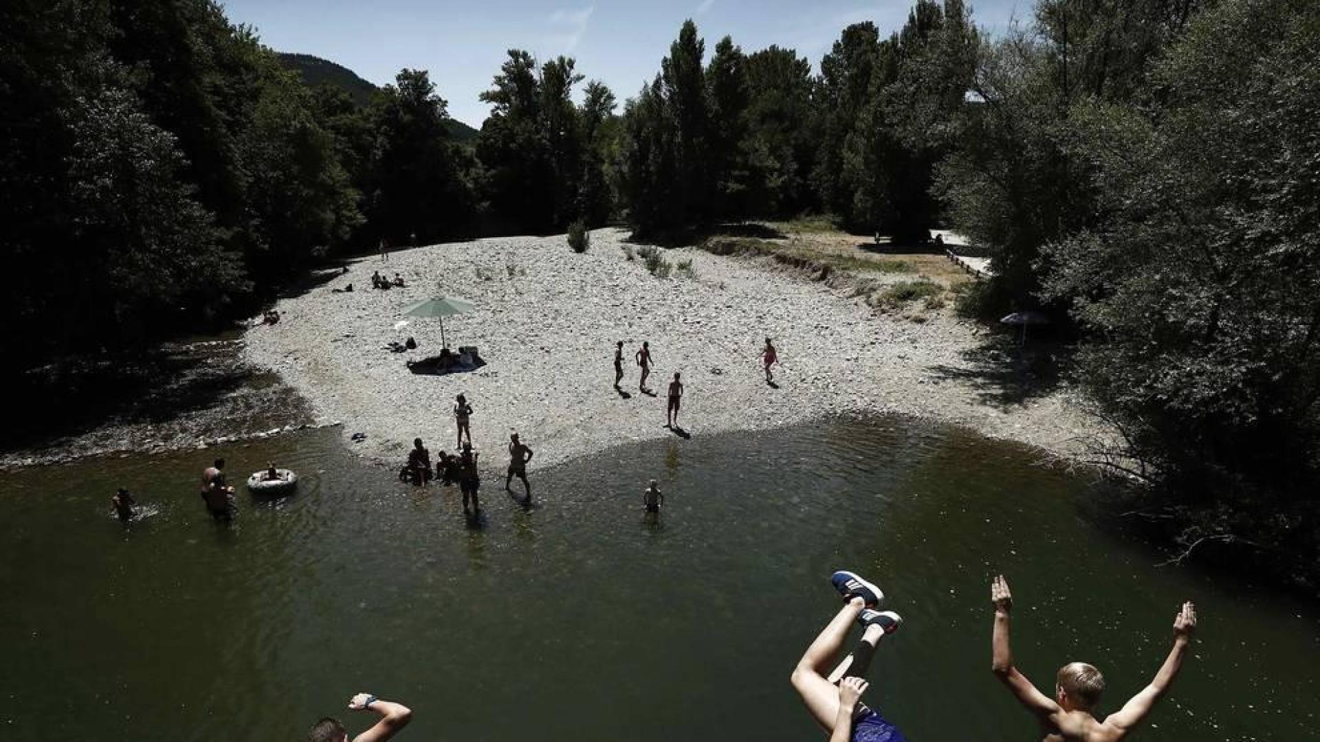 Varias personas se alivian del calor en el pantano de Alloz y en el río Arga a su paso por Irotz.