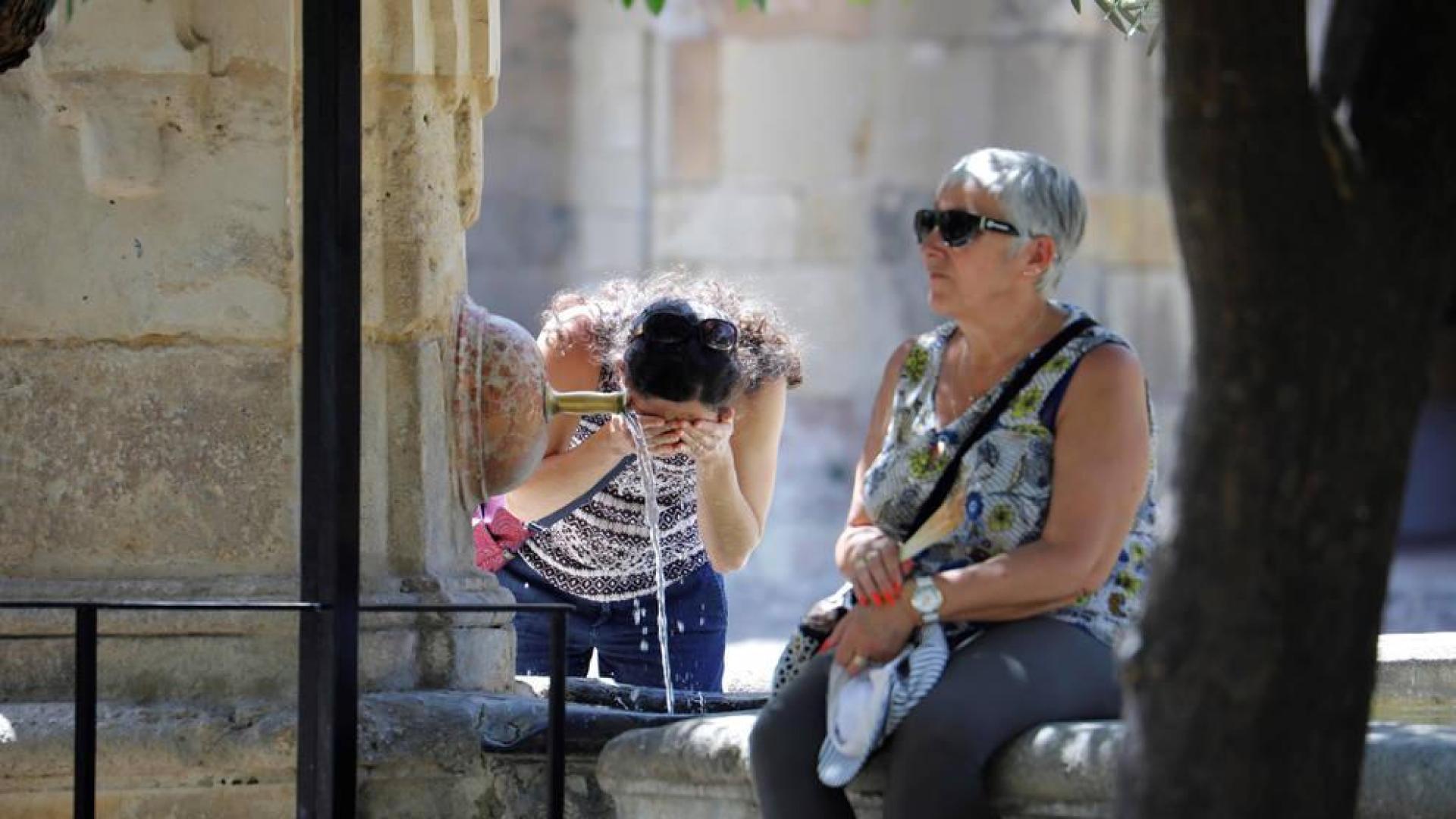 Una turista se refresca en una de las fuentes del patio de los Naranjos de la Mezquita-Catedral de Córdoba.