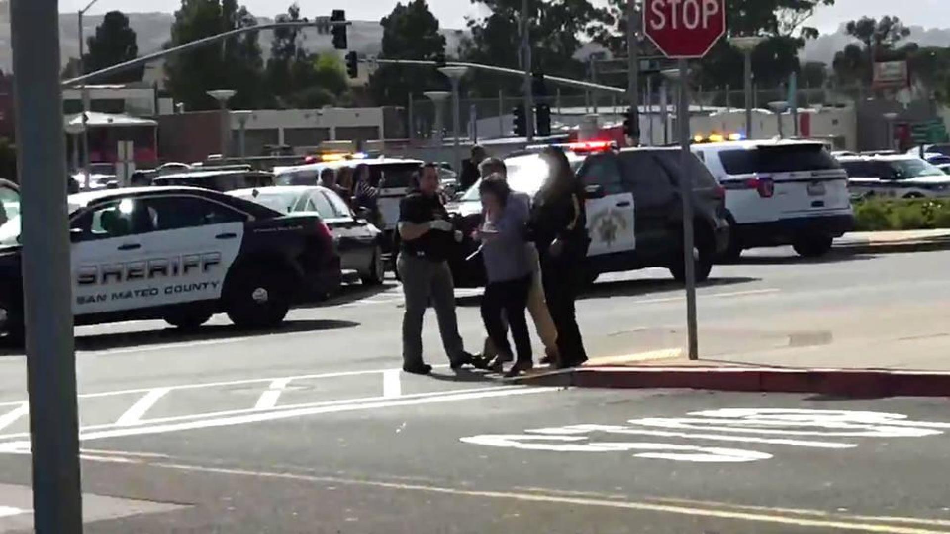 Varios policías ayudan a los ciudadanos tras el tiroteo en el centro comercial de San Bruno, en San Francisco.