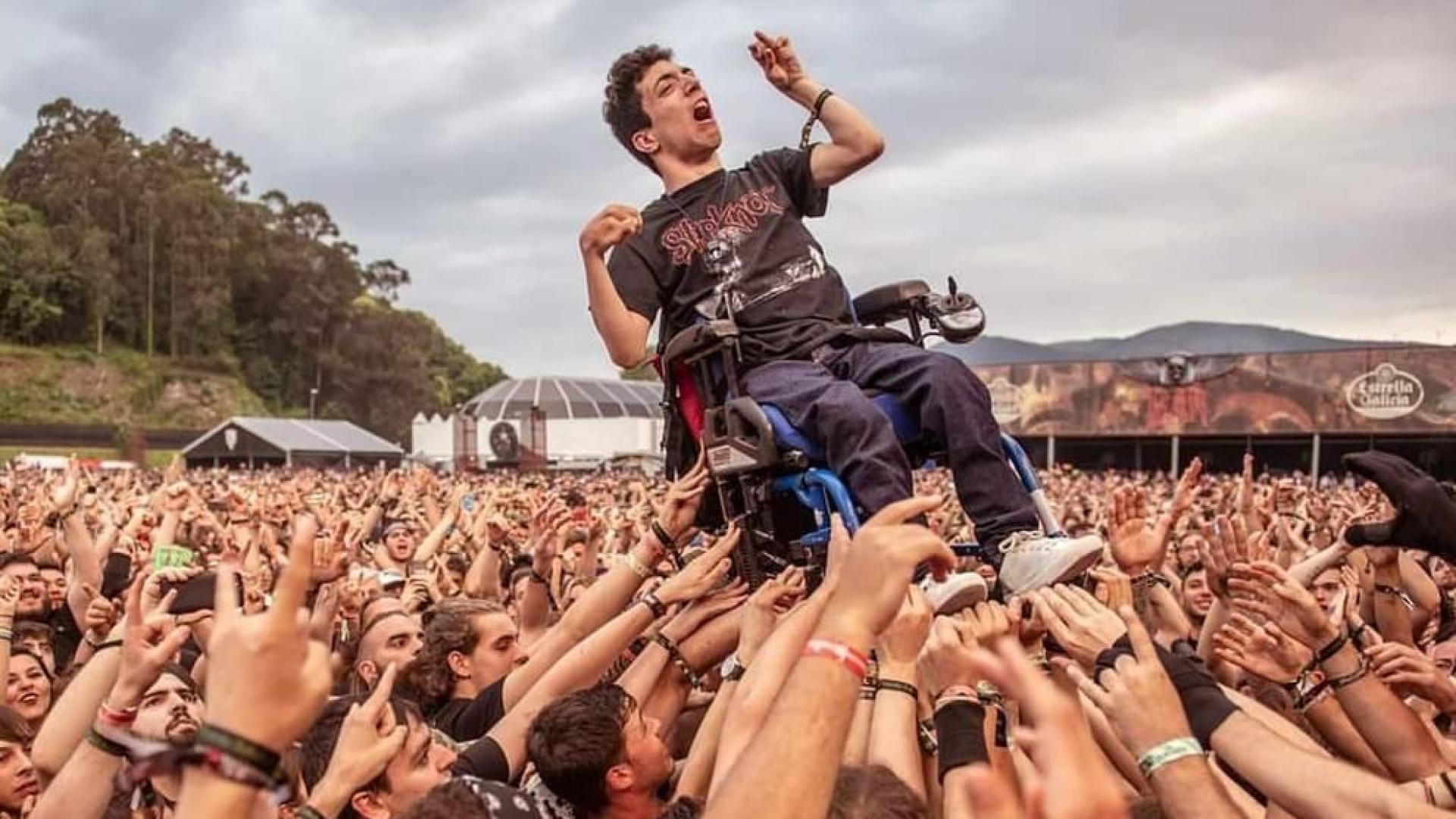 El público aupa a un joven en silla de ruedas en un festival de heavy metal