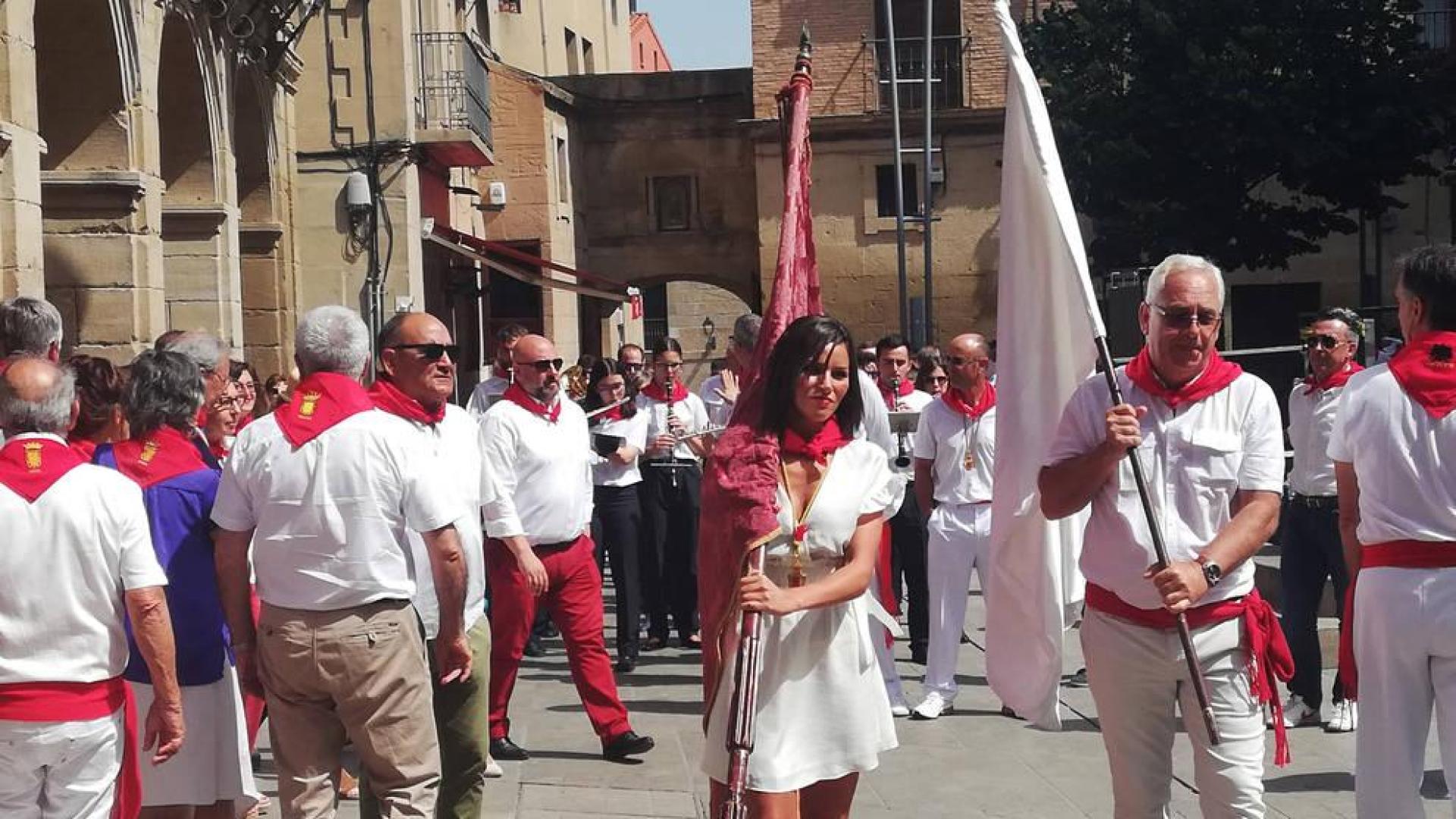 La edil de NA+, Sara Ojanguren, como abanderada, junto con François Frey, concejal de La Brède (Francia) con la bandera de su localidad.