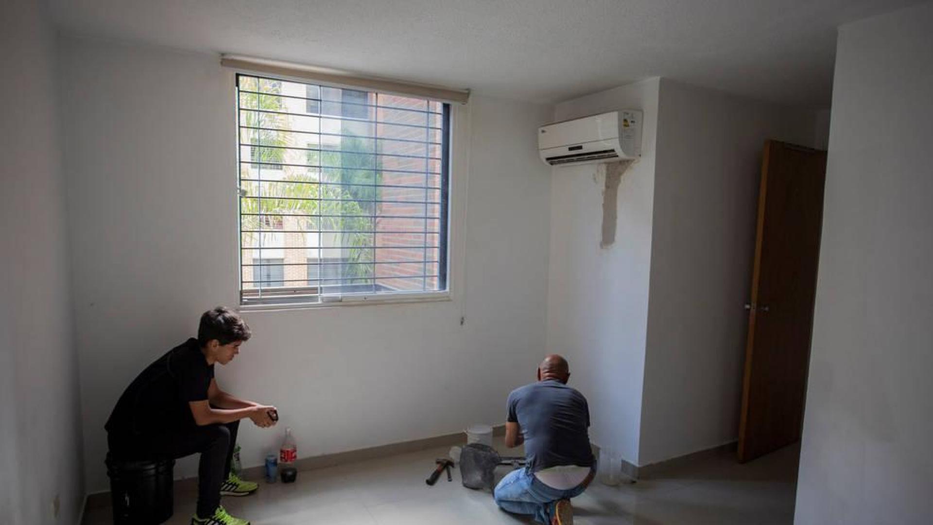 Foto que muestra a un hombre trabajando en una habitación de una de las viviendas que mantienen Silvia Fuenmayor y Amelí Mata a sus clientes en Caracas (Venezuela)