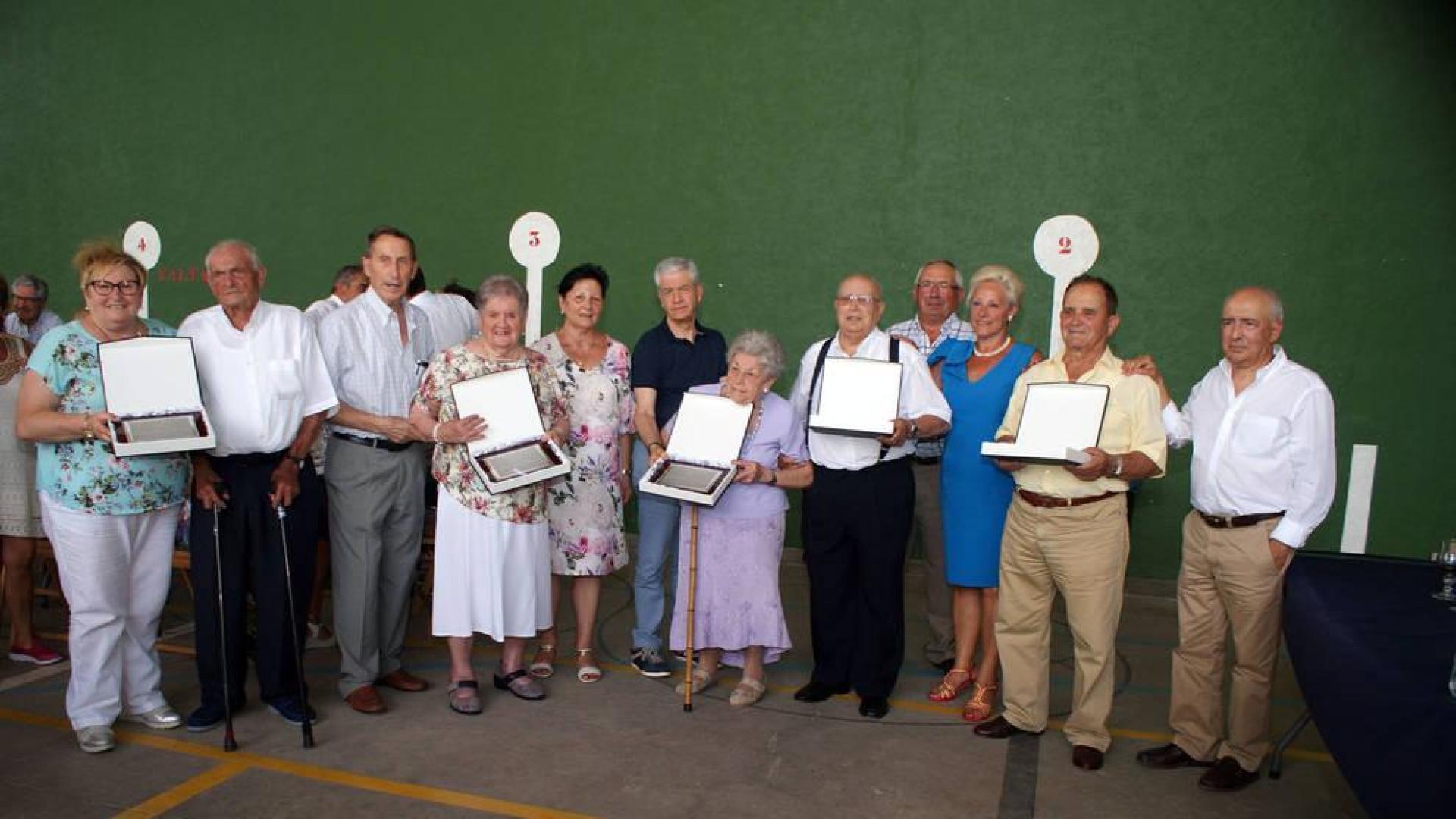 De izda. a dcha, con sus placas, las personas que recibieron el homenaje: Antonio Jiménez (con bastones), Adela Sangüesa, Joaquina Rodríguez, Tomás Úcar y Jesús Fuentes, con familiares y miembros de la directiva del Club de Jubilados Alegría y Amistad.