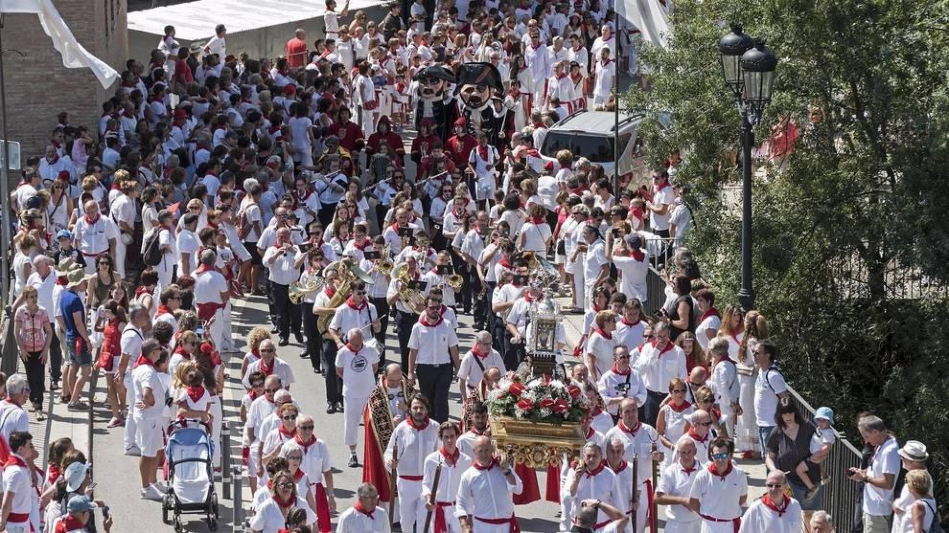 La reliquia de San Andrés enfila el puente del Azucarero en la retaguardia de la larga procesión. Detrás, los párrocos, la banda y la corporación municipal.