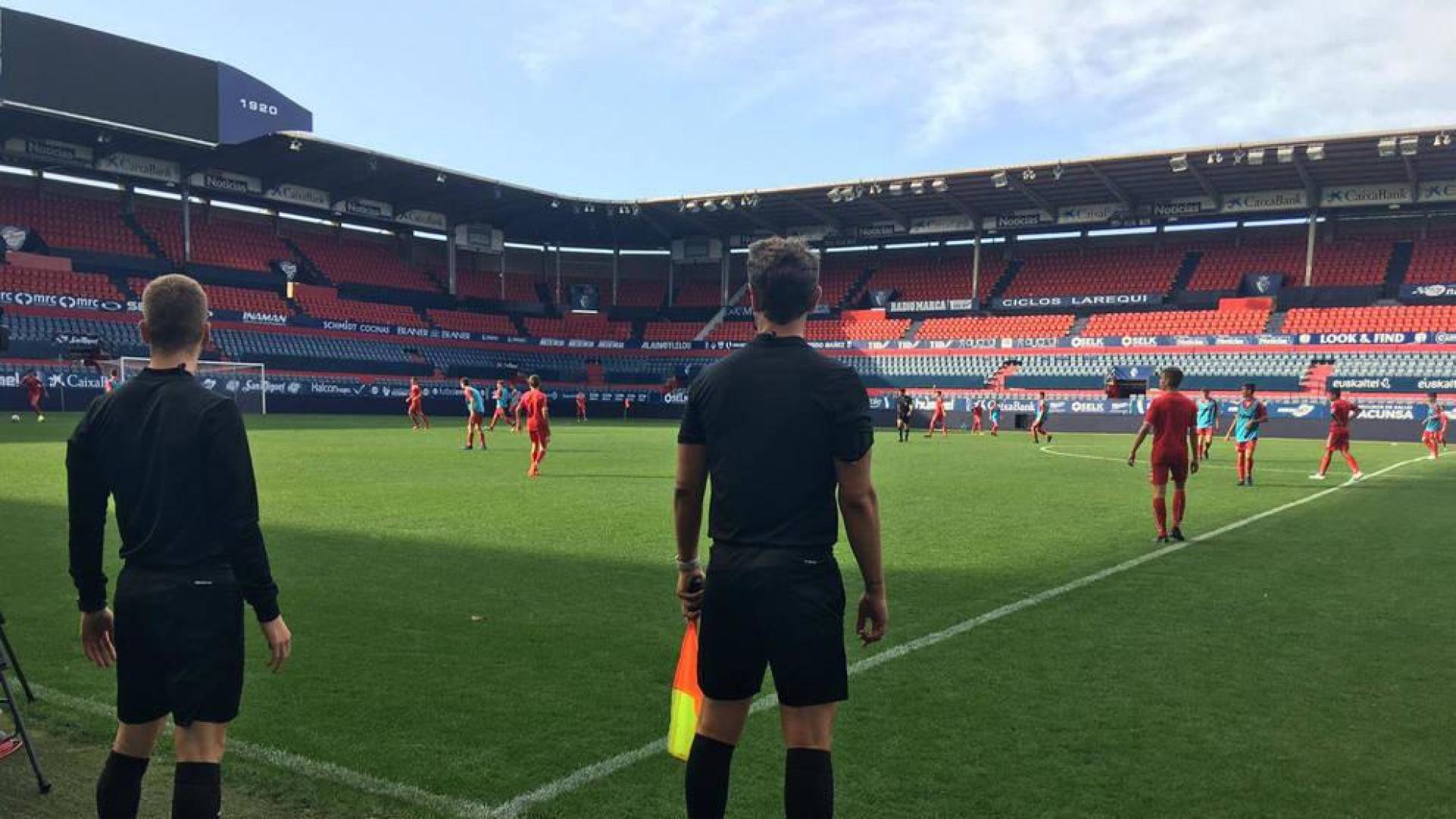 Los cadetes de Osasuna disputan el partido de ensayo ante la mirada del cuarteto arbitral.