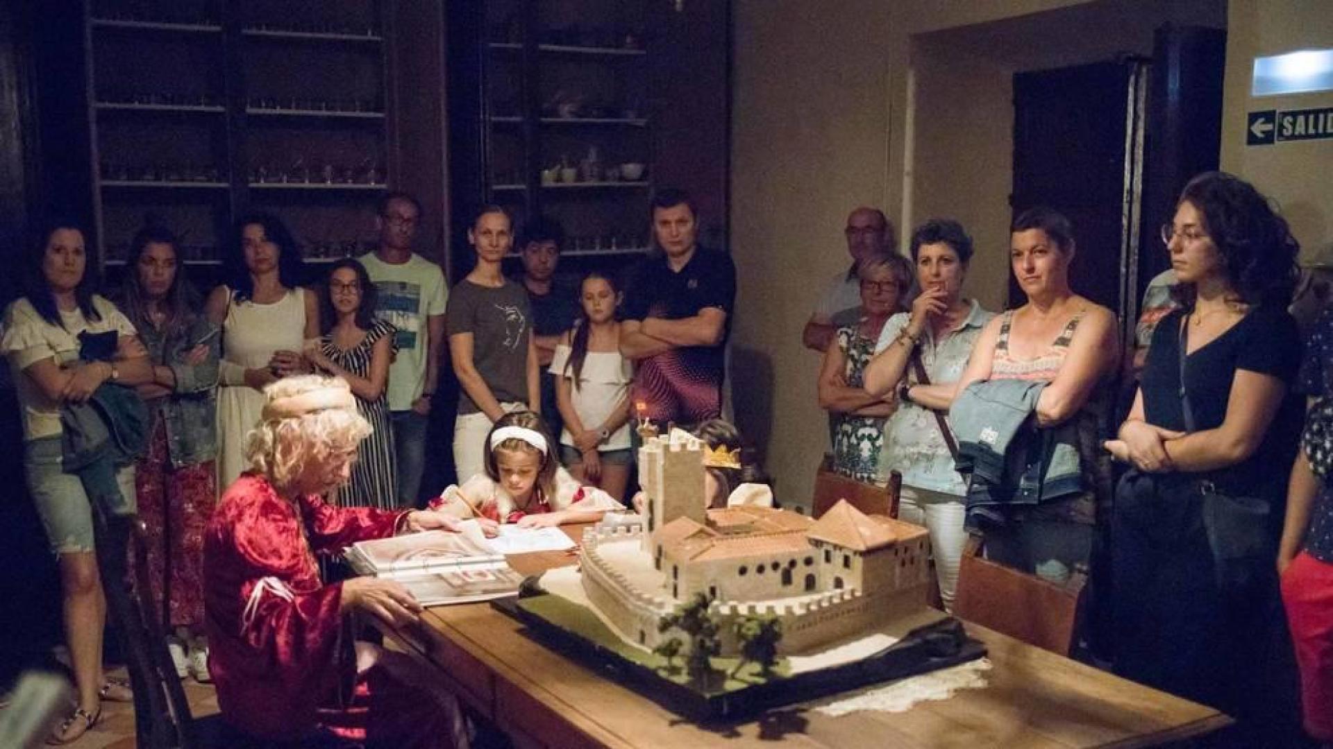 Los visitantes miran con atención a las infantas, que dibujan bajo la supervisión de una dama en el comedor habilitado para ellas