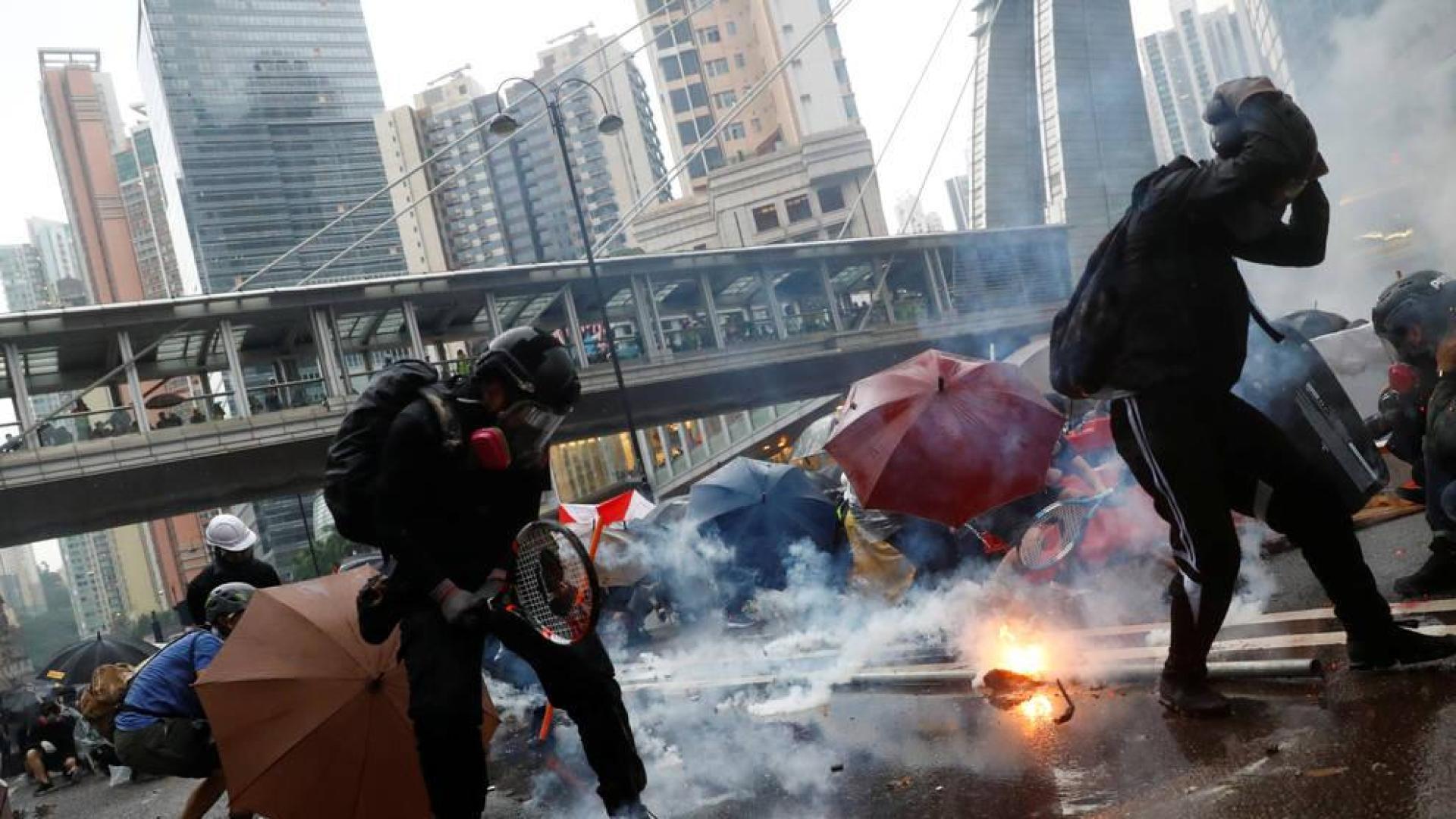 Manifestantes se defienden del gas lacrimógeno de la policía en Hong Kong.