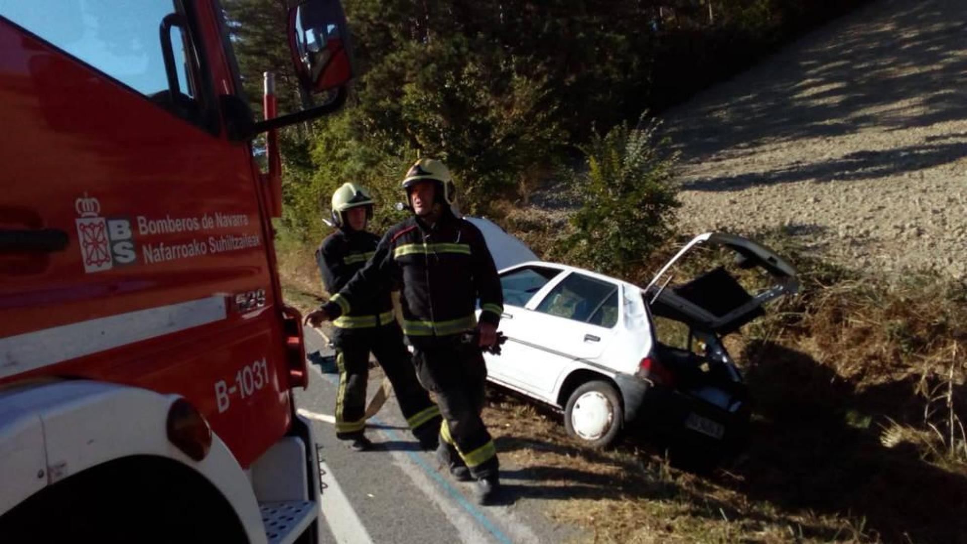 Bomberos, en el lugar del accidente, con el vehículo detrás.