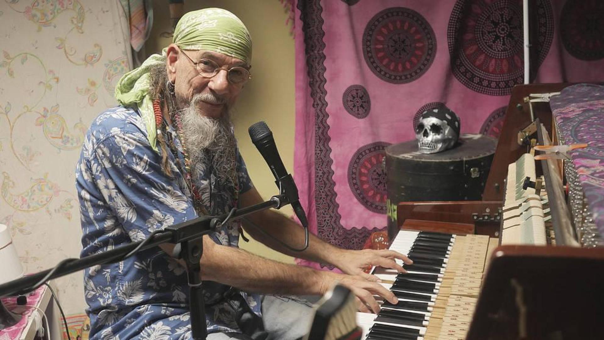 Enrique Villarreal,  El Drogas, sentado al piano en el que compone sus canciones.
