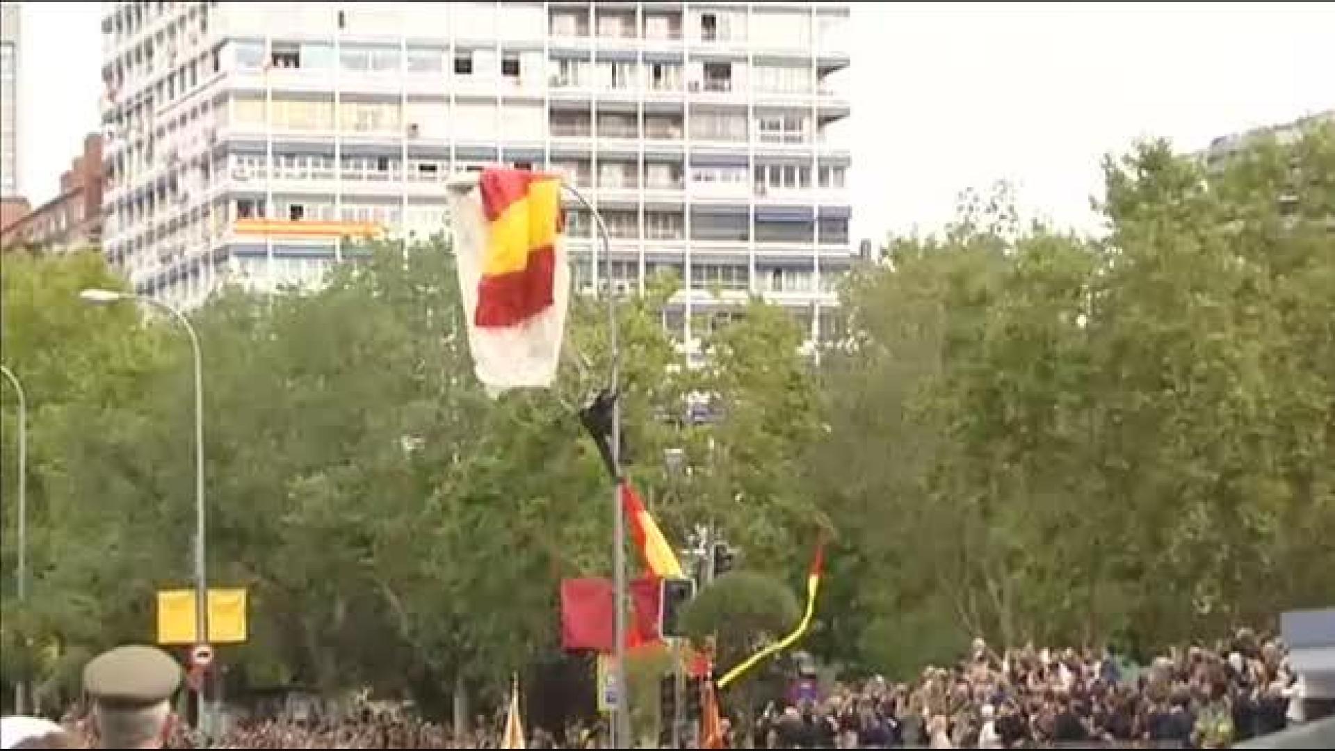 Un paracaidista se queda enganchado a una farola en el desfile del Día de la Hispanidad
