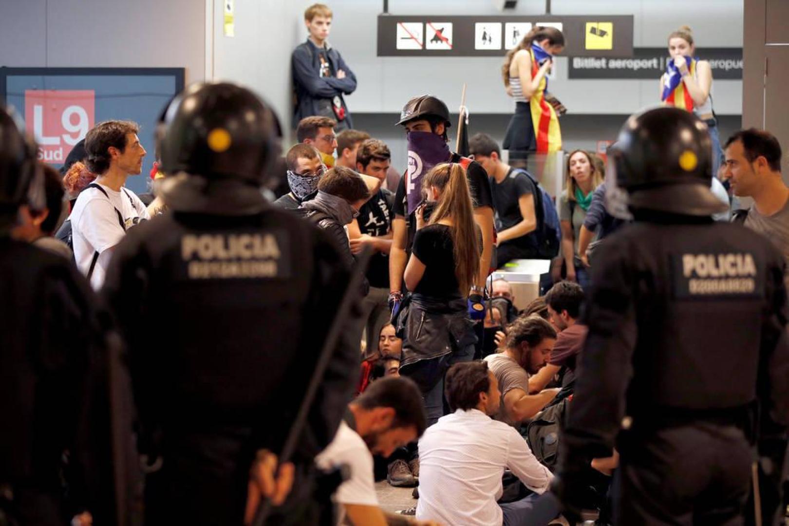 Agentes de los Mossos d'Esquadra controlan a los simpatizantes independentistas que han conseguido entrar en el T1 del Aeropuerto de El Prat.