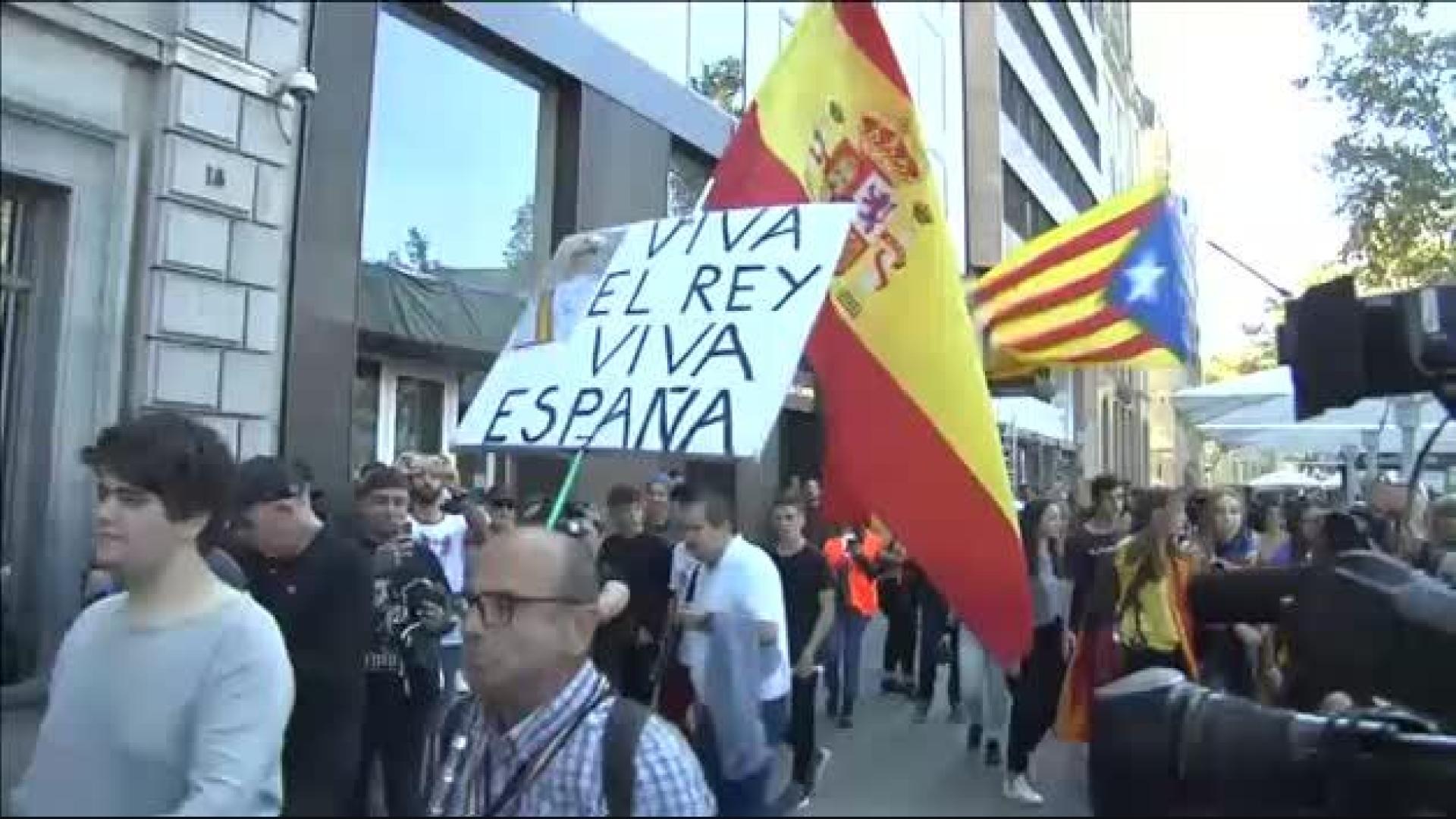 Escoltan a un hombre con la bandera de España durante la manifestación de estudiantes en Barcelona
