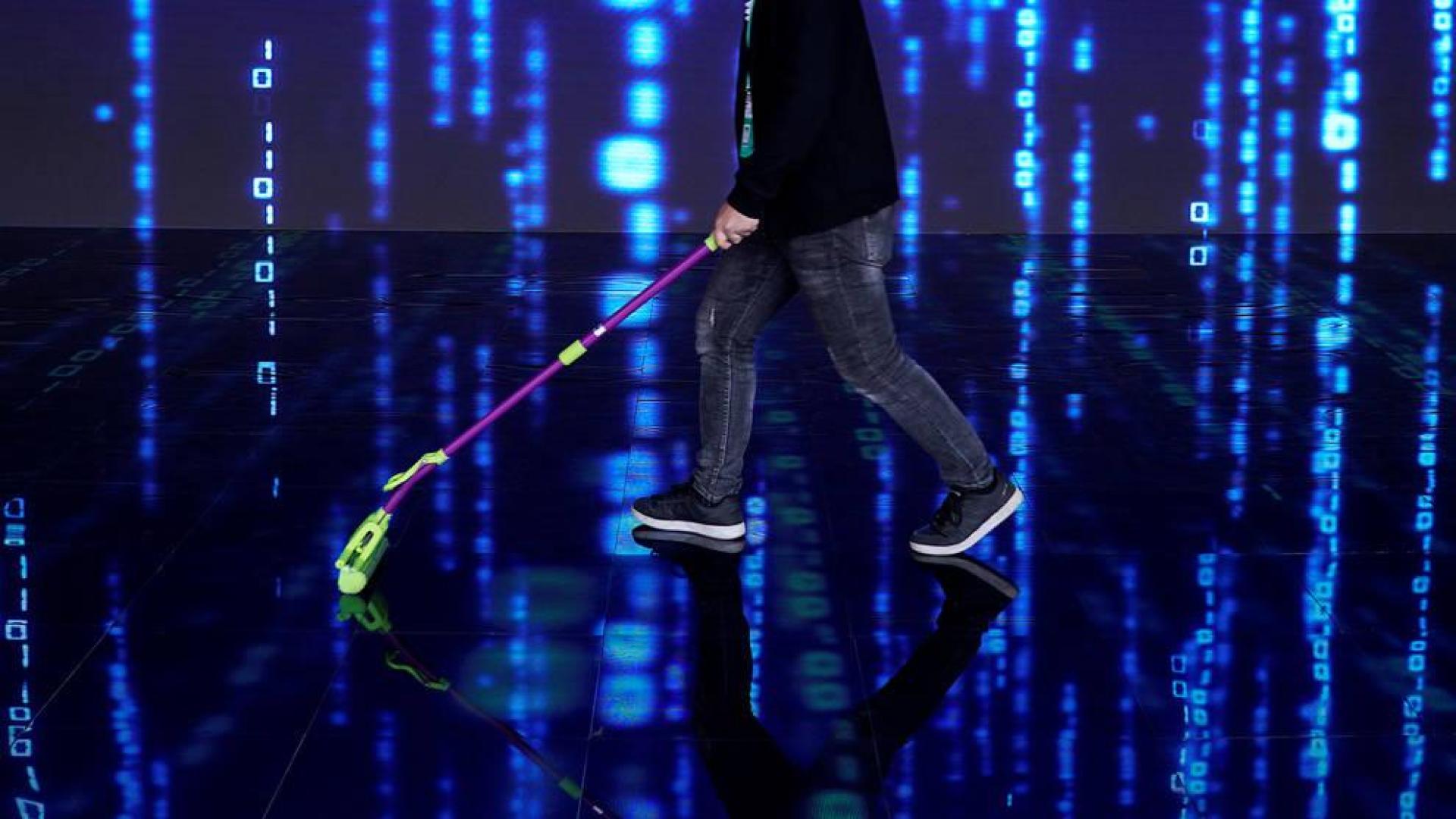 Un hombre limpia el suelo junto a una pantalla en la Conferencia Mundial de Internet en la localidad china de Wuzhen.
