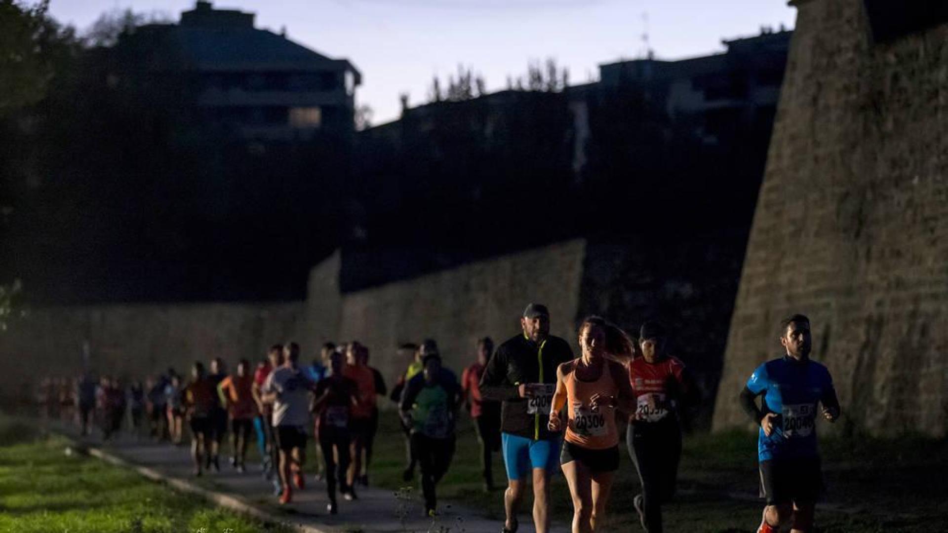 Un grupo de participantes, a la carrera por los fosos de la Ciudadela de Pamplona