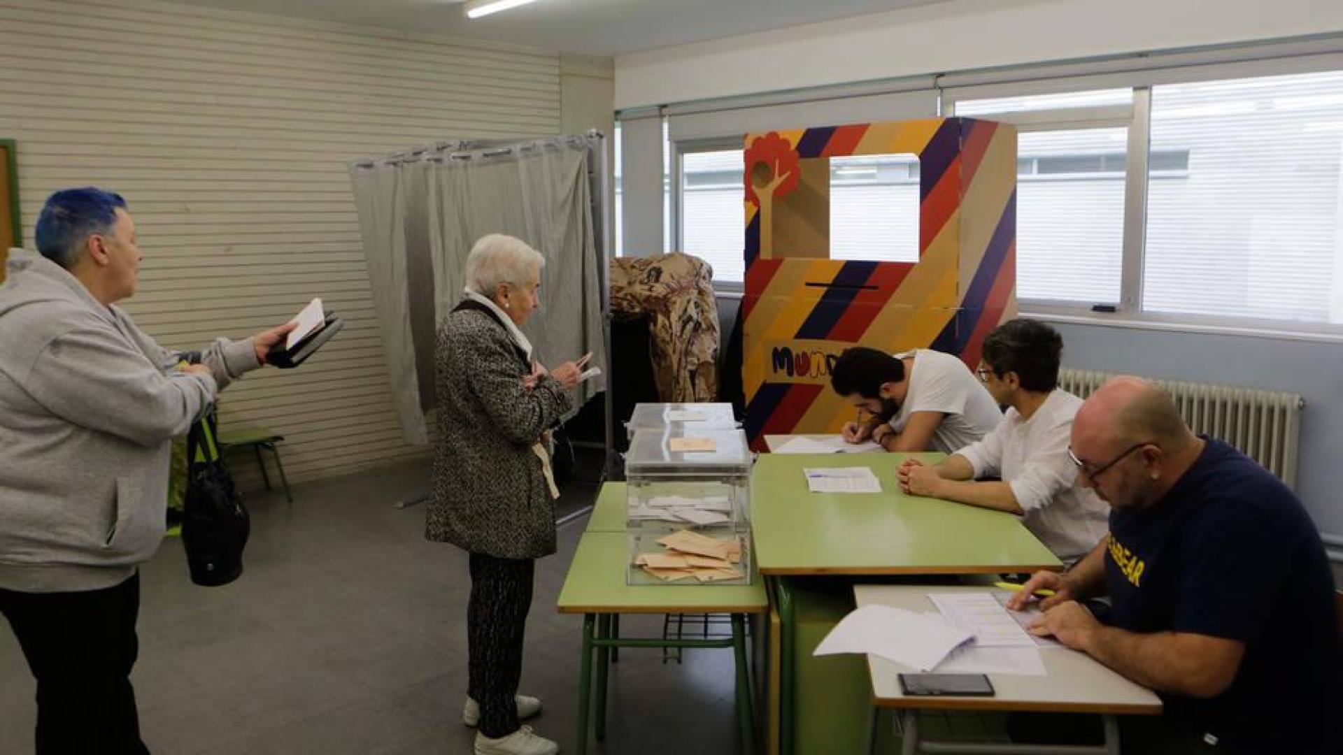 Varias personas votando en un colegio electoral del barrio de Mendillorri en Pamplona
