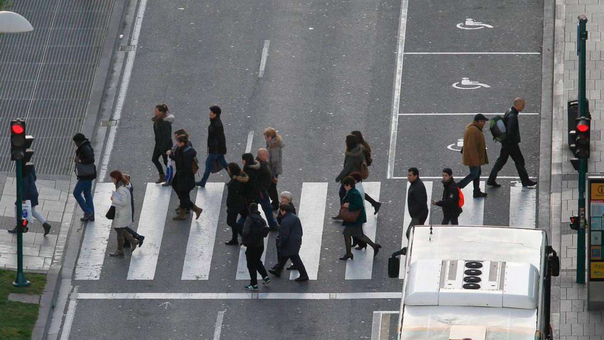 Varias personas cruzan un paso de peatones de Pamplona.