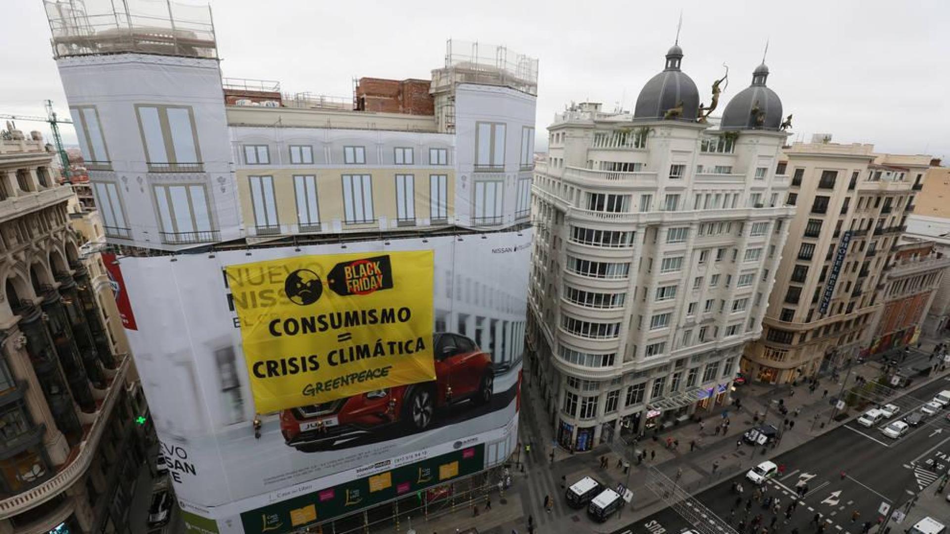 Greenpeace coloca una gran pancarta en Gran Vía para criticar el consumo "masivo"