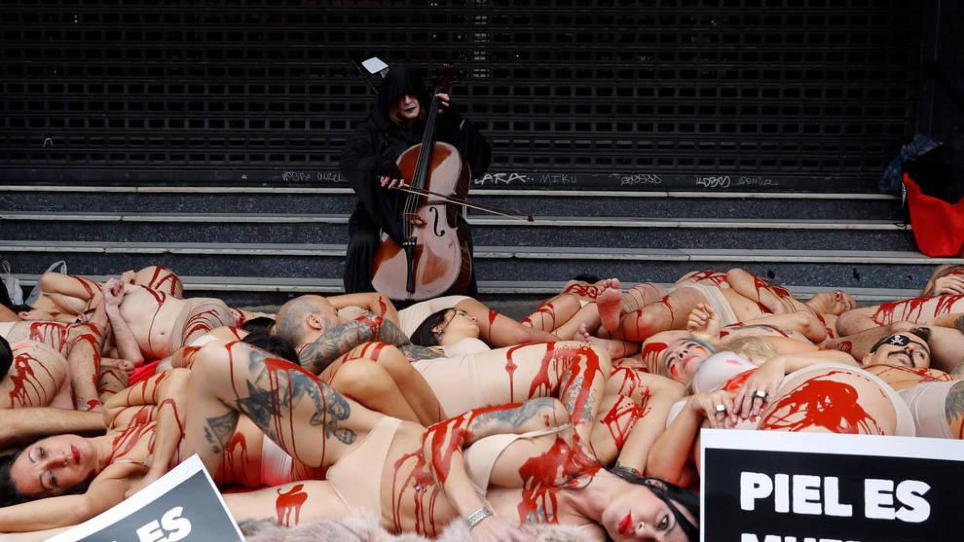 Activistas protestan contra la industria peletera simulando ser animales desollados