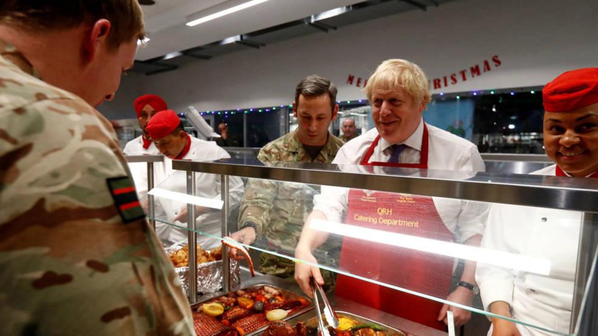 Boris Johnson visita a sus tropas en Estonia y les sirve comida prenavideña