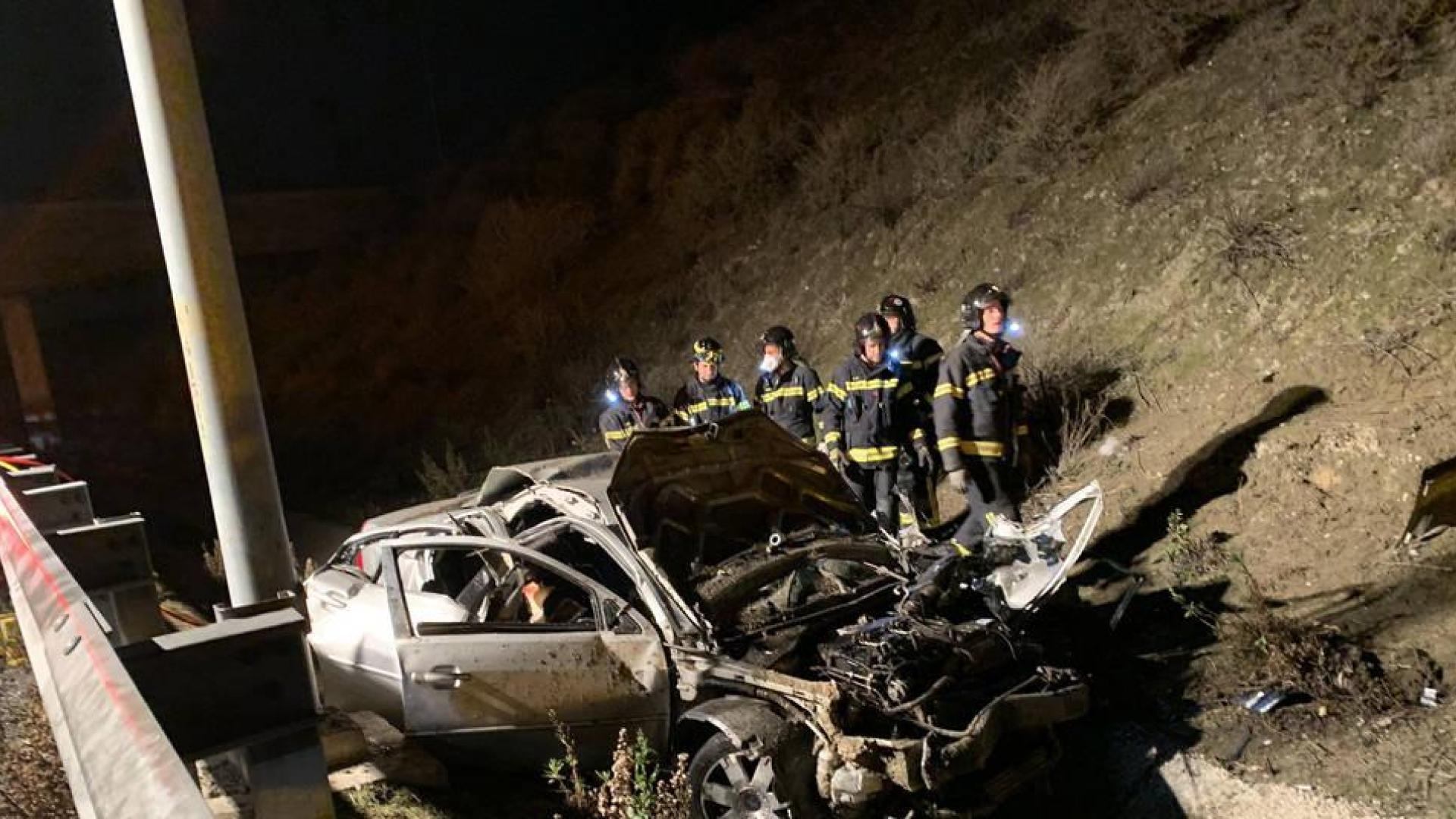 Bomberos de Madrid junto al coche accidentado en la M50.