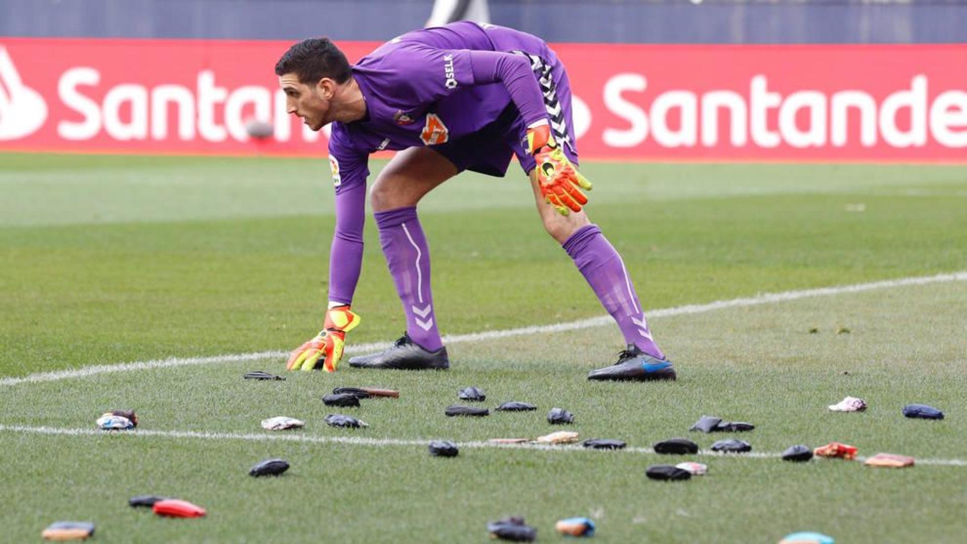 Sergio Herrera recoge una de las carteras lanzadas desde la grada de El Sadar.