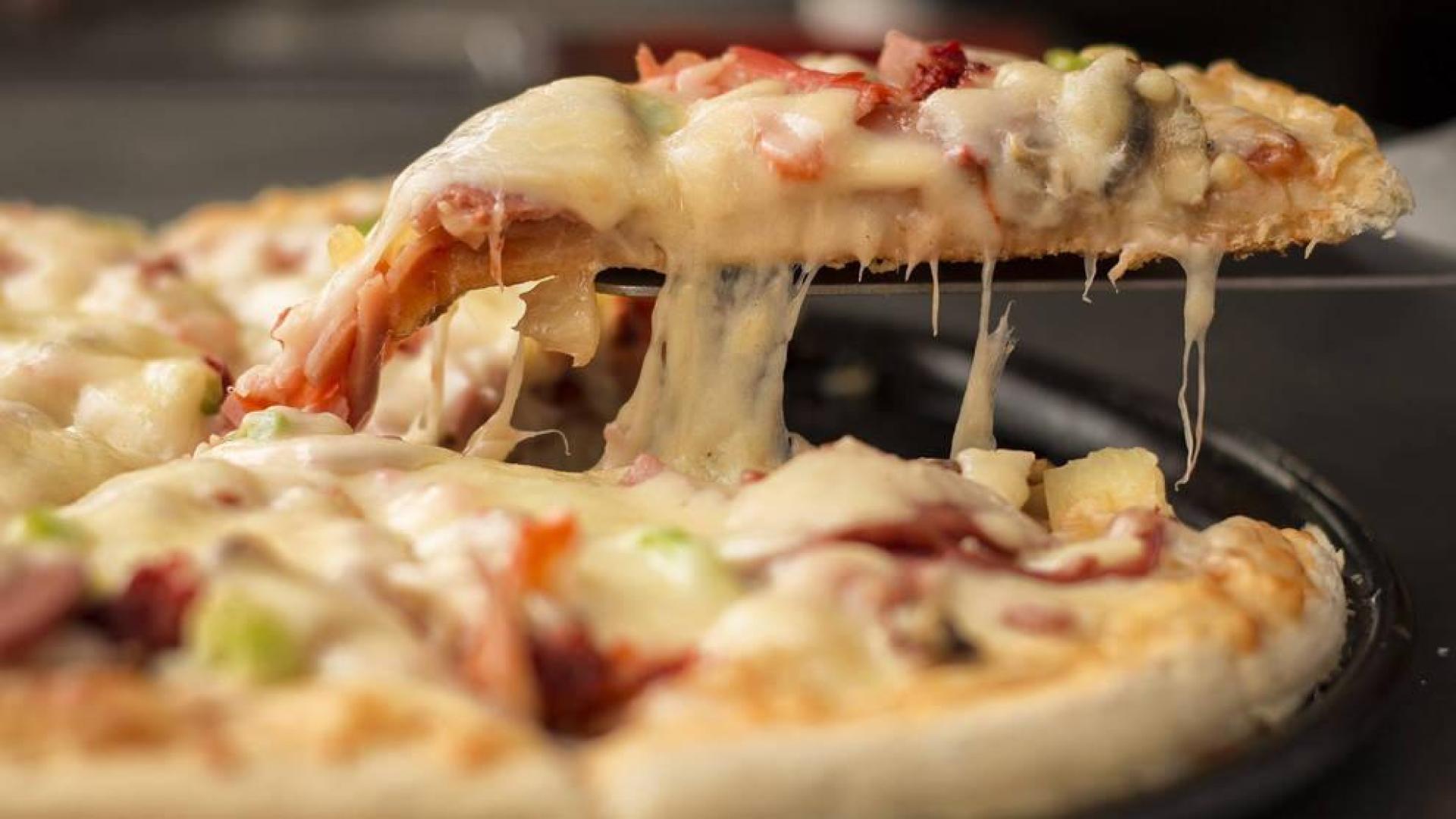 Una persona sirve una pizza.